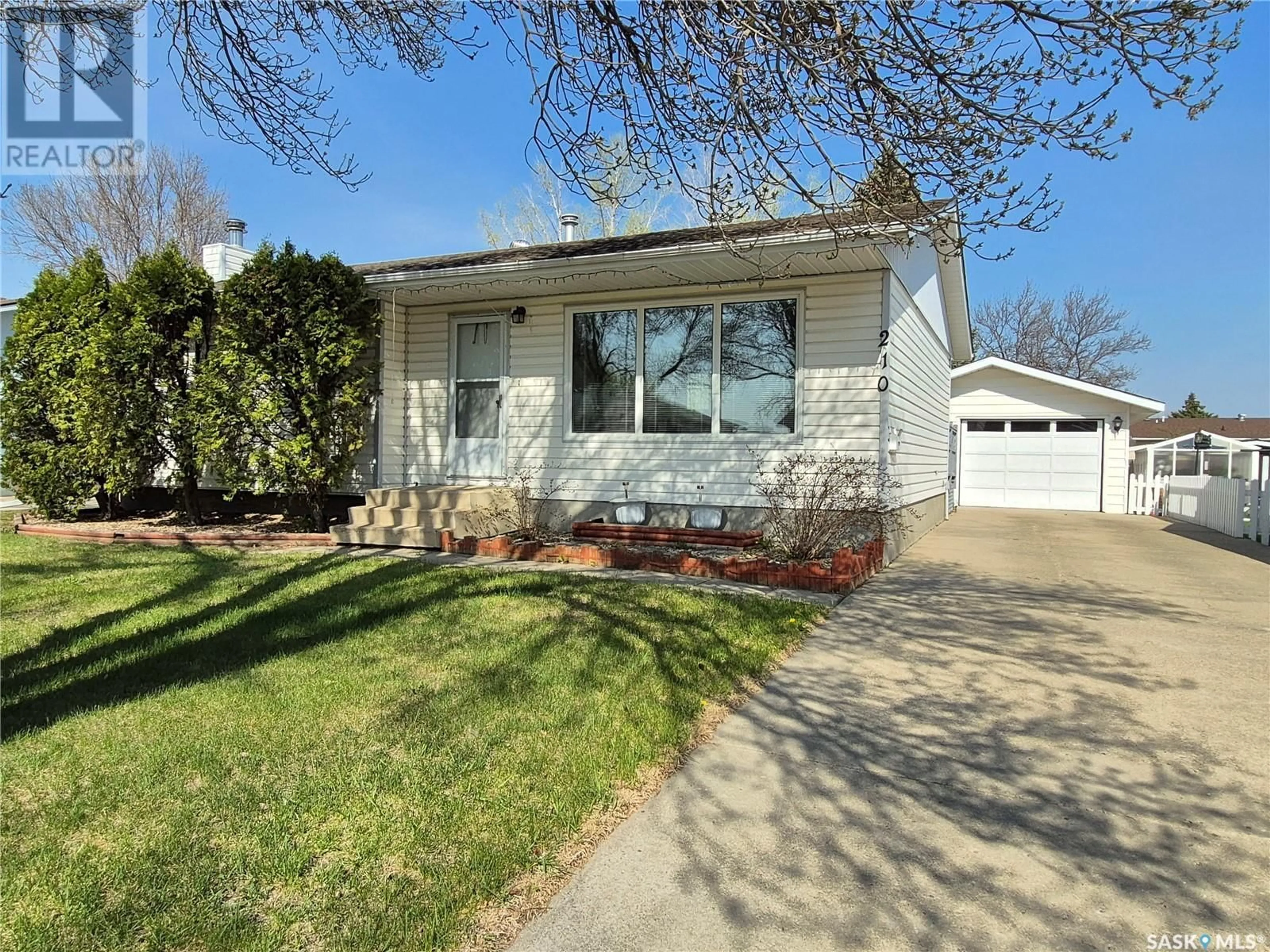 Home with vinyl exterior material, street for 210 HARVEY BAY, Weyburn Saskatchewan S4H2S7