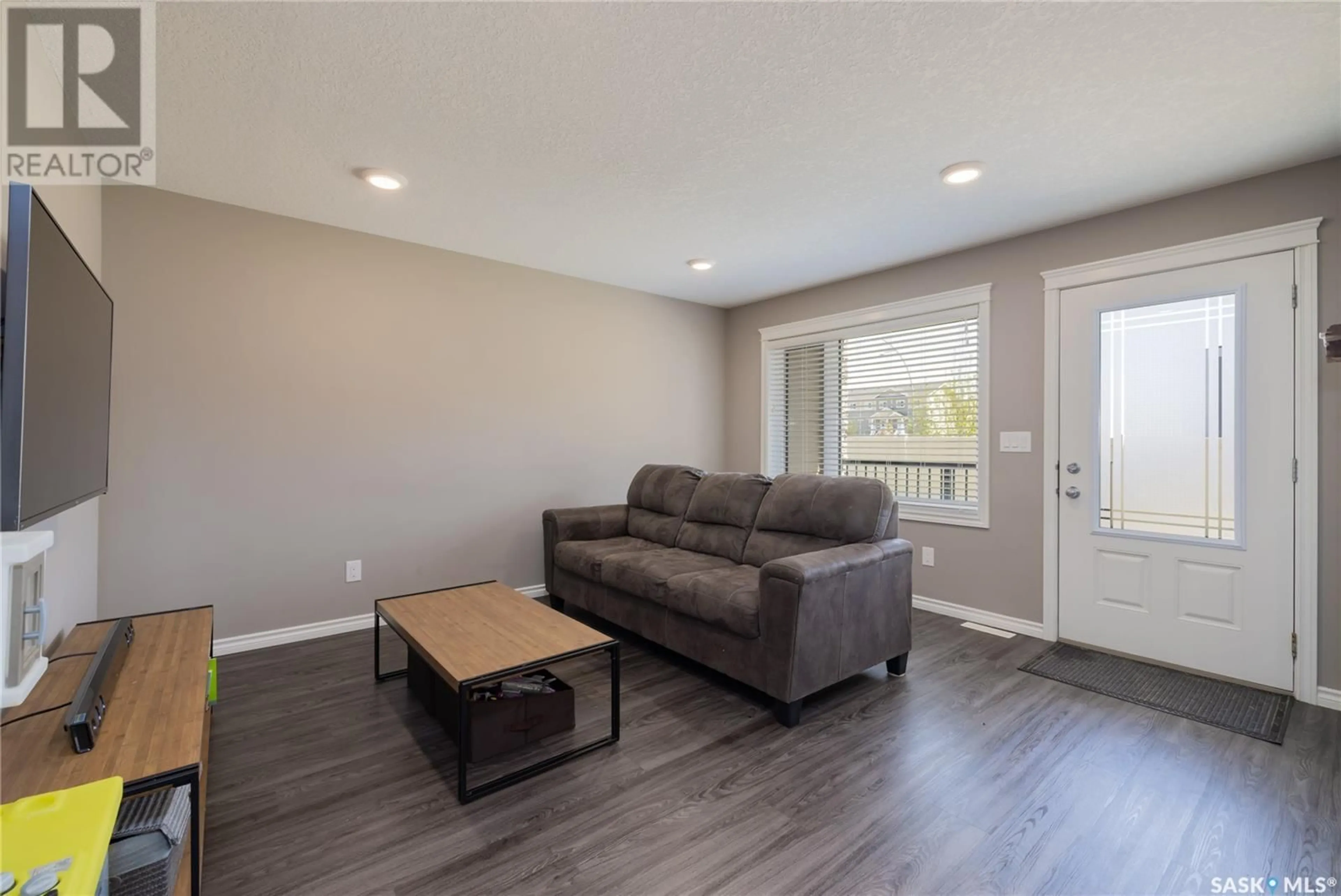 Living room with furniture, wood/laminate floor for 110 - 104 AKHTAR BEND, Saskatoon Saskatchewan S7W0Y9
