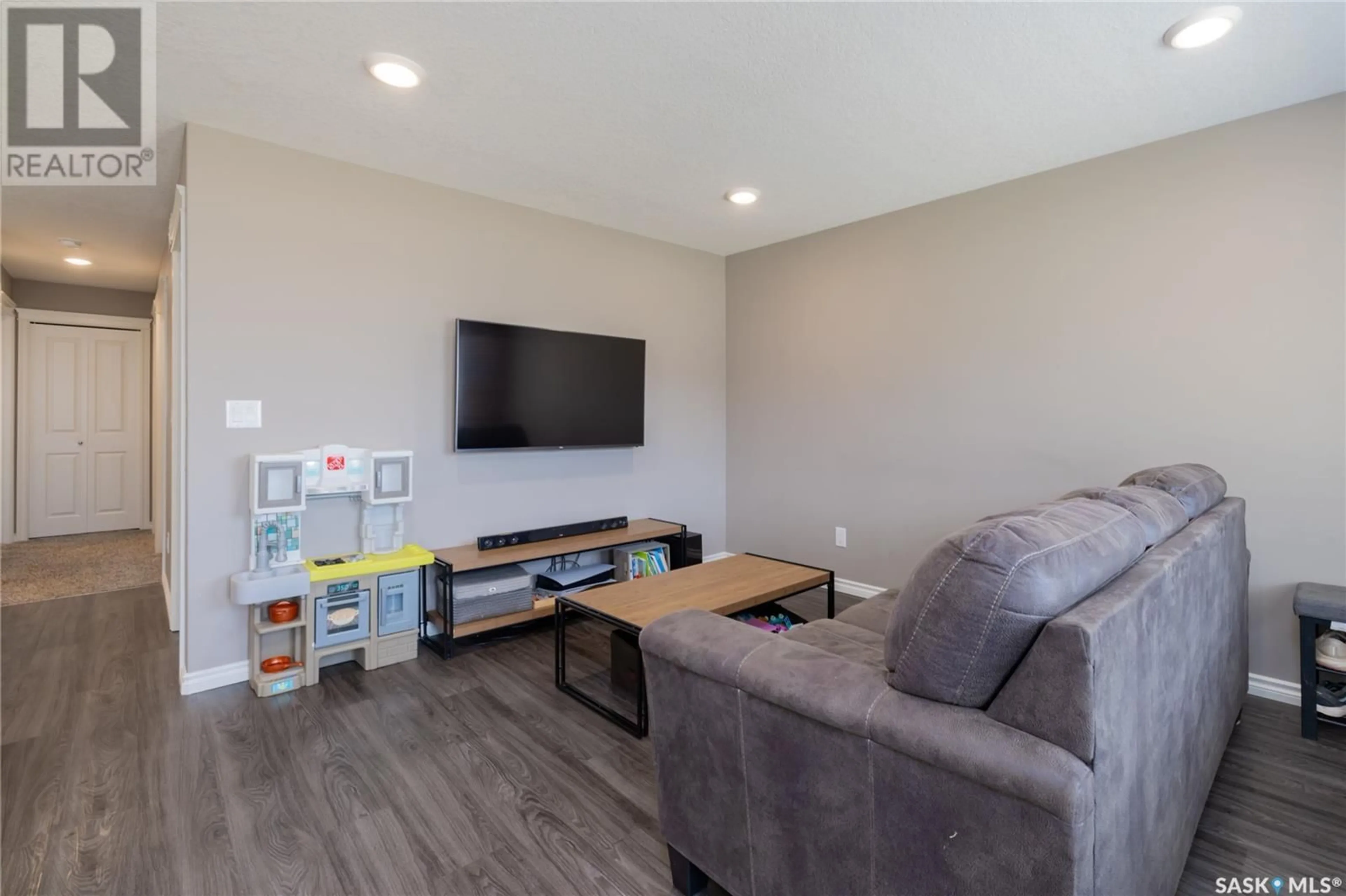 Living room with furniture, wood/laminate floor for 110 - 104 AKHTAR BEND, Saskatoon Saskatchewan S7W0Y9