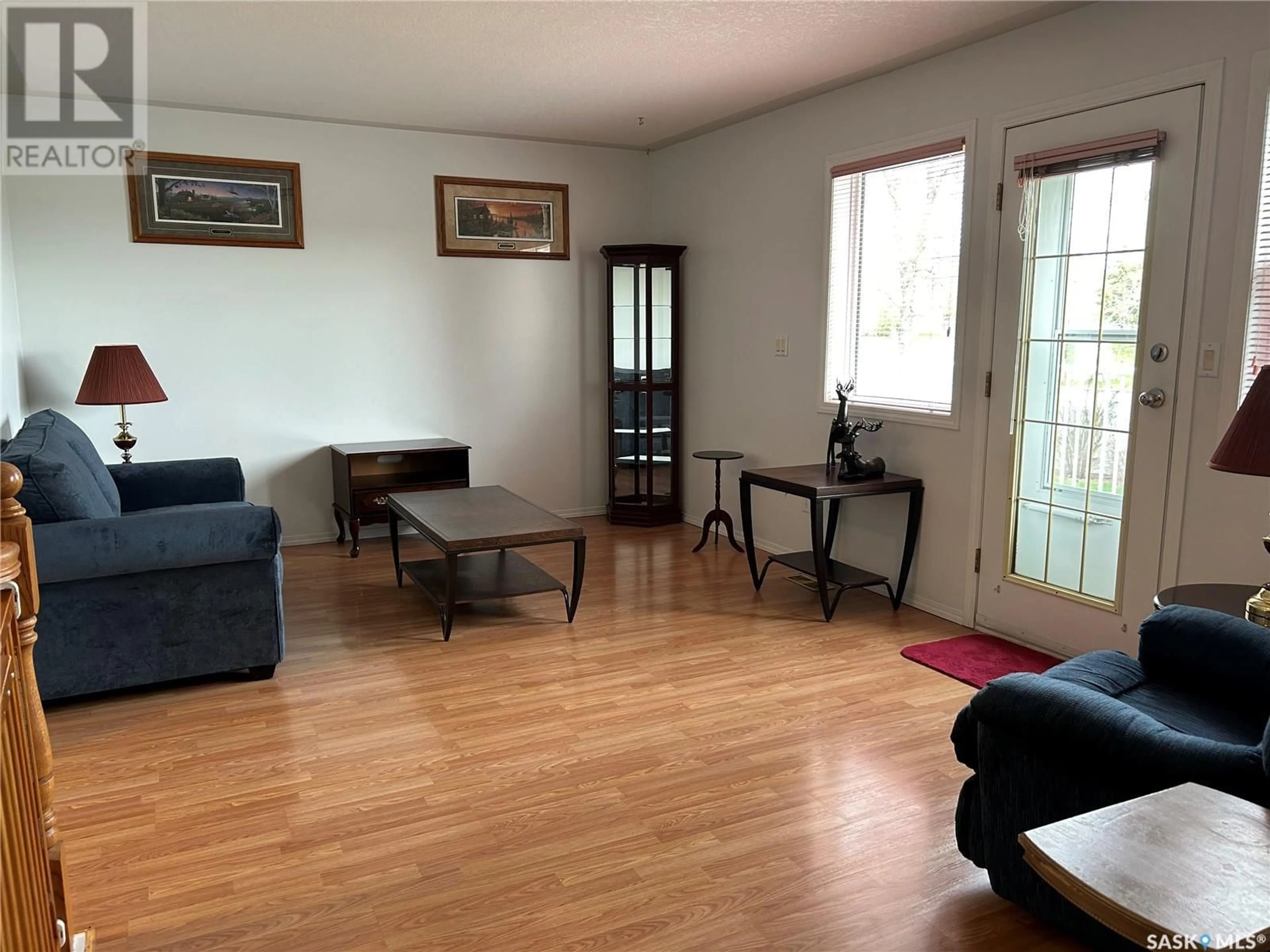 Living room with furniture, wood/laminate floor for 102 - 1091 TAISEY CRESCENT, Estevan Saskatchewan S4A2V2