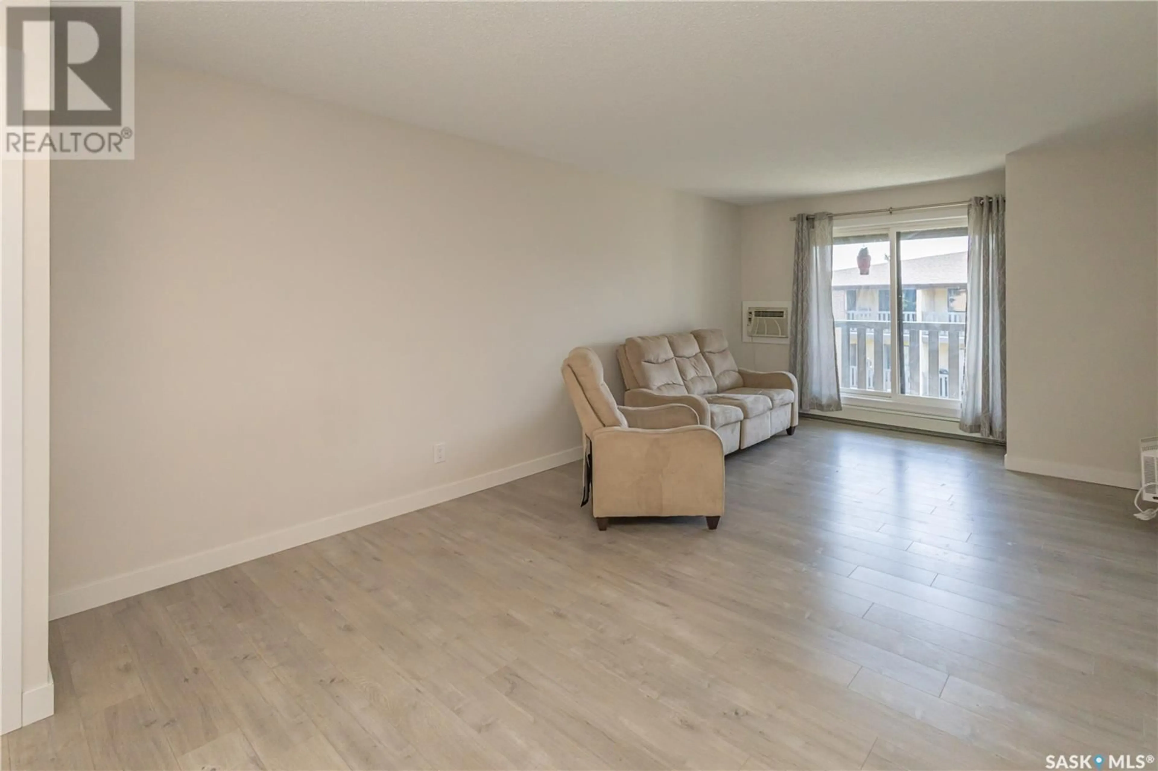 Living room with furniture, wood/laminate floor for 310 315 TAIT CRESCENT, Saskatoon Saskatchewan S7H5L6