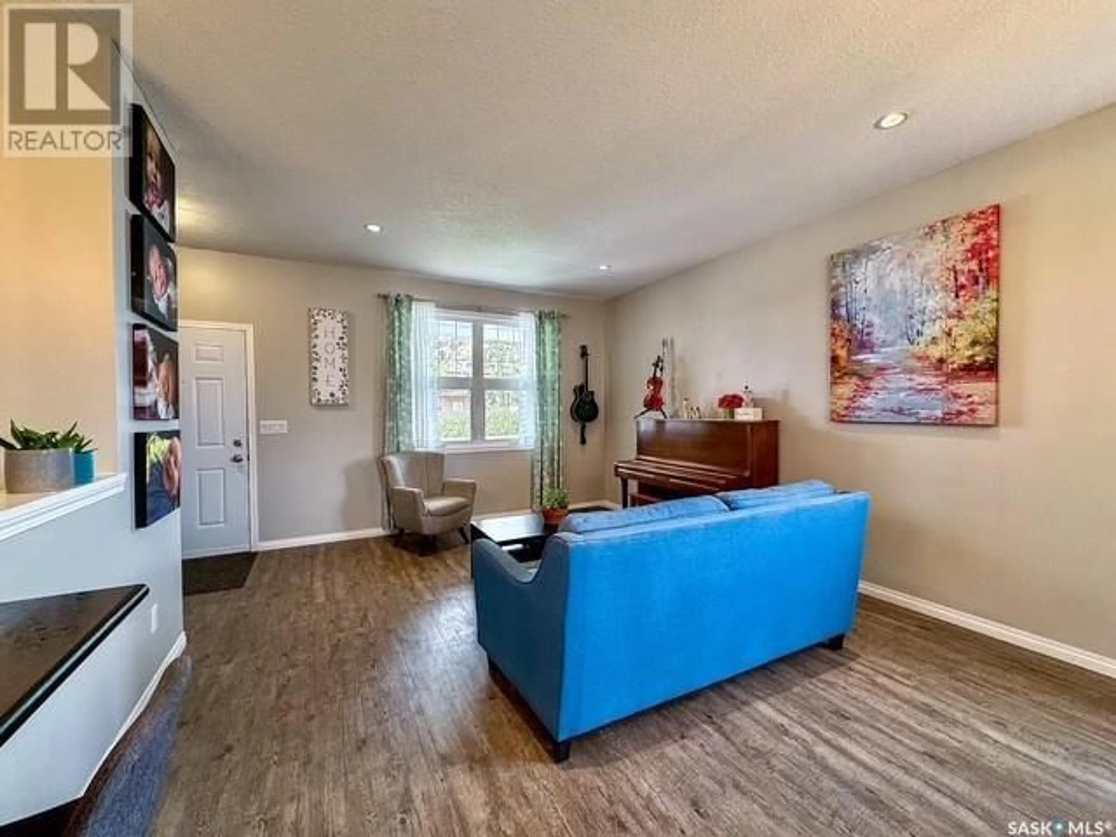Living room with furniture, wood/laminate floor for NE - 23 9TH AVENUE, Swift Current Saskatchewan S9H2R9
