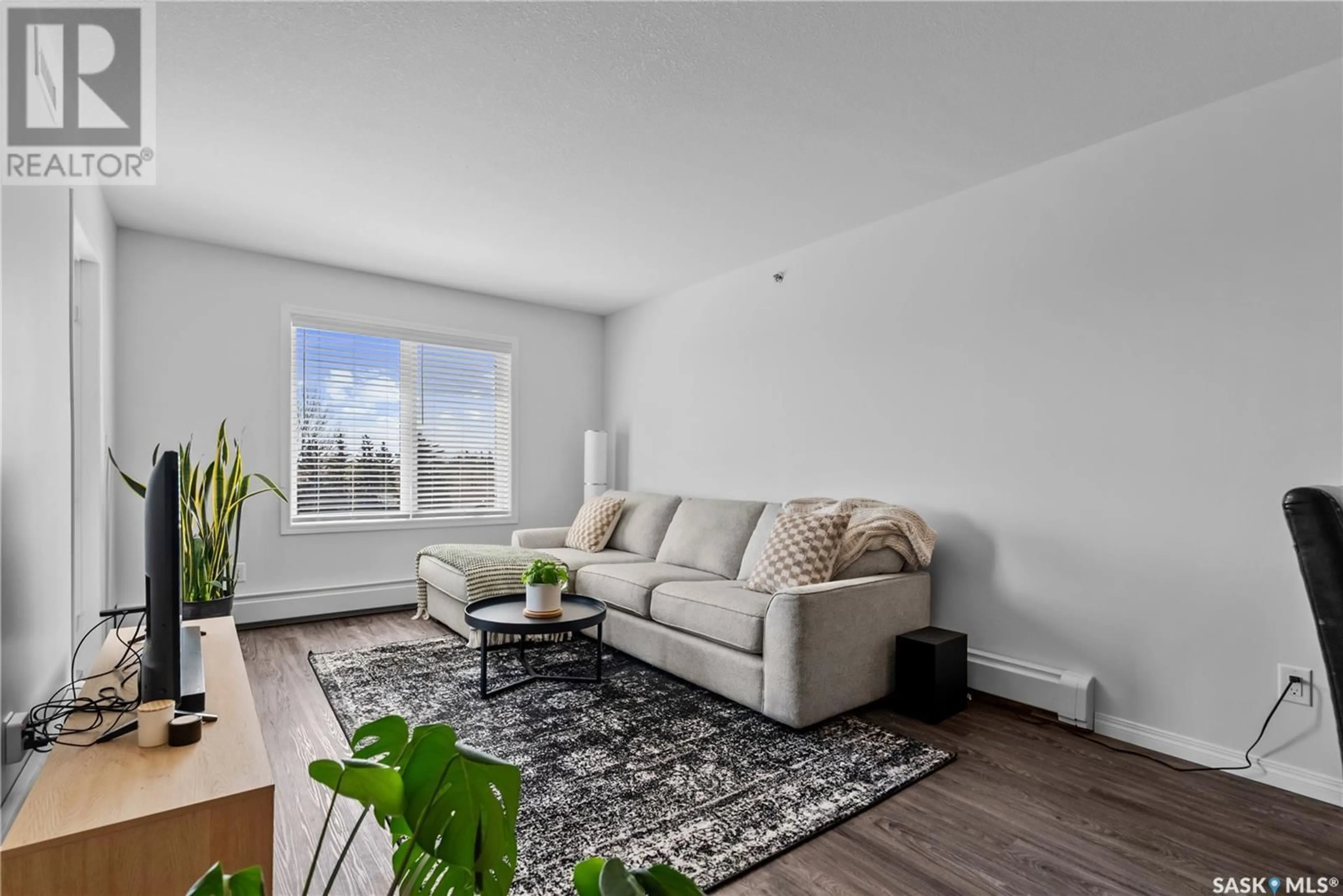 Living room with furniture, wood/laminate floor for 405 - 2452 KILLDEER DRIVE, North Battleford Saskatchewan S9A3T5