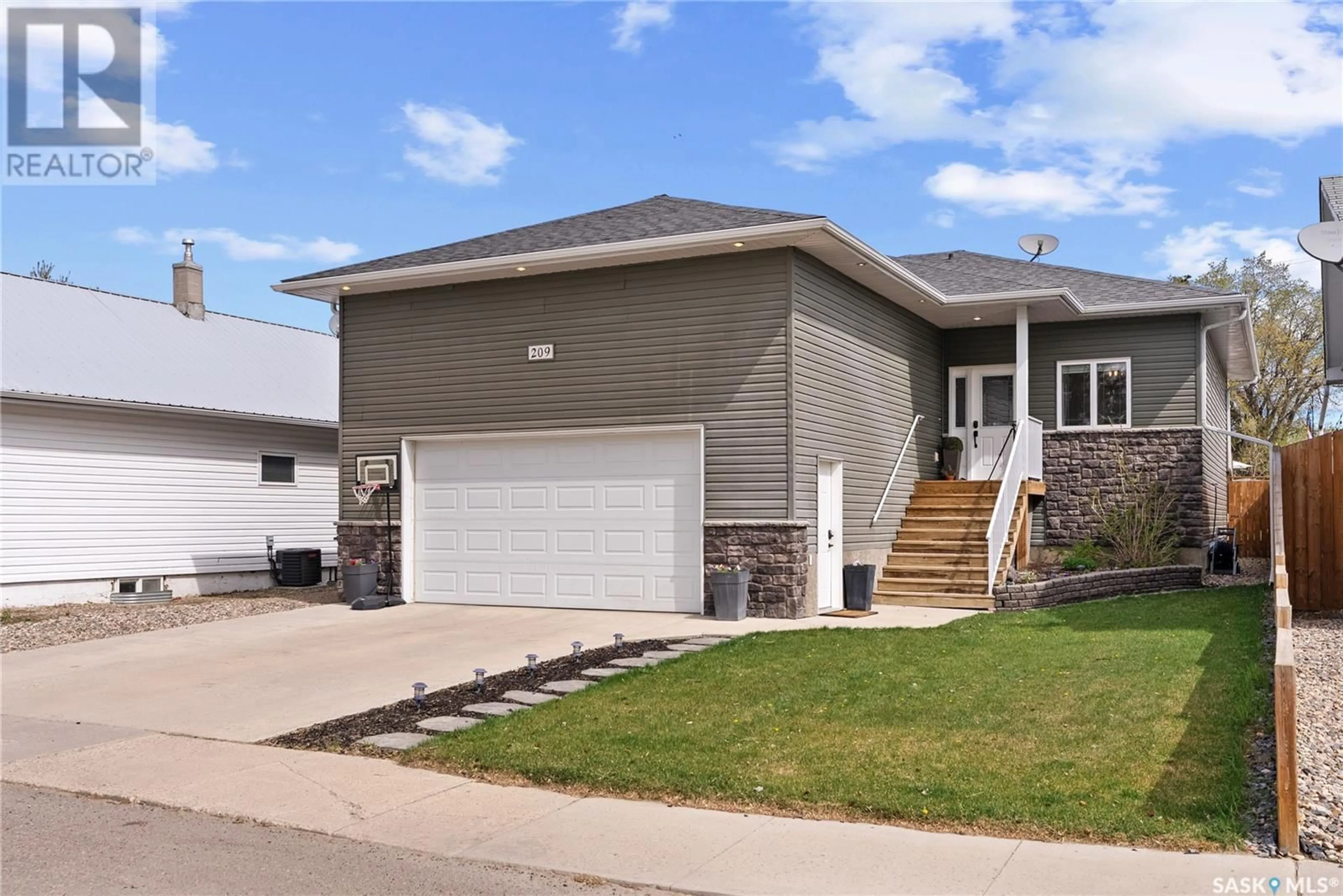 Home with vinyl exterior material, street for 209 5TH AVENUE, Biggar Saskatchewan S0K0M0