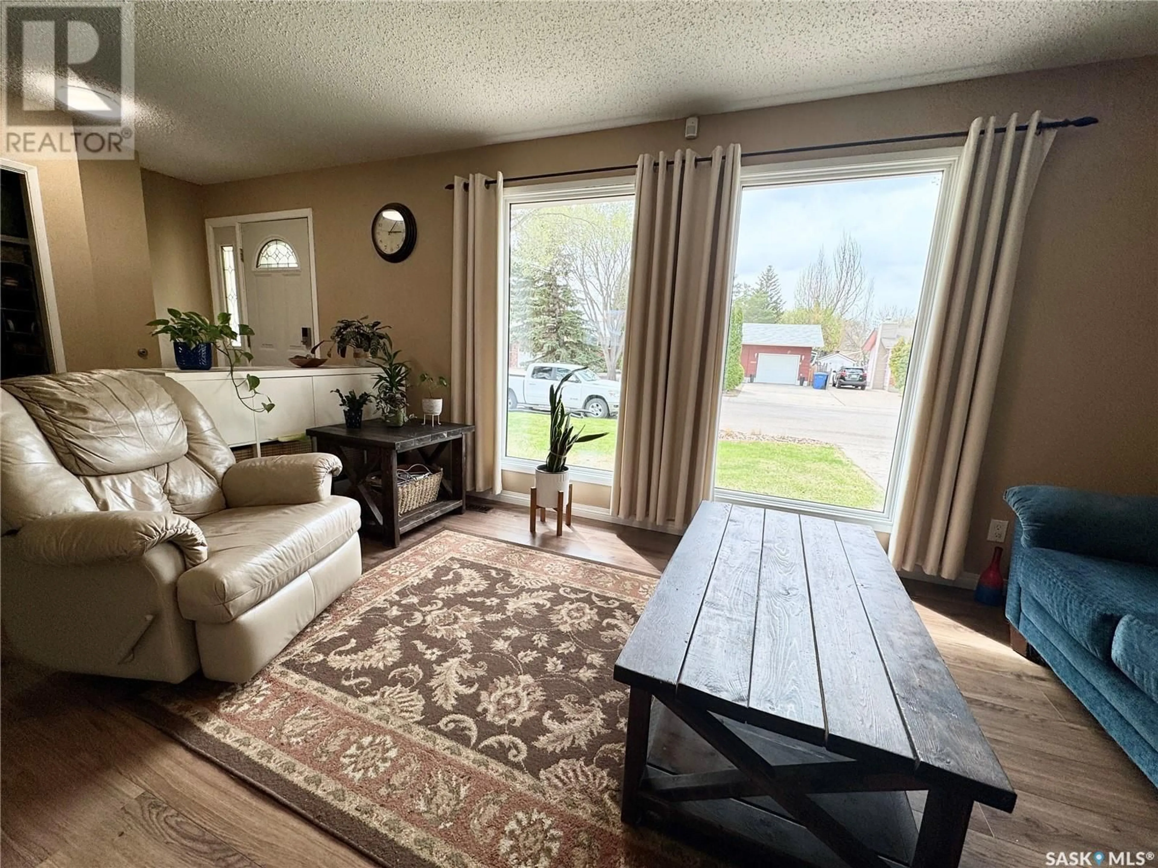 Living room with furniture, wood/laminate floor for 10820 MEIGHEN CRESCENT, North Battleford Saskatchewan S9A3L3