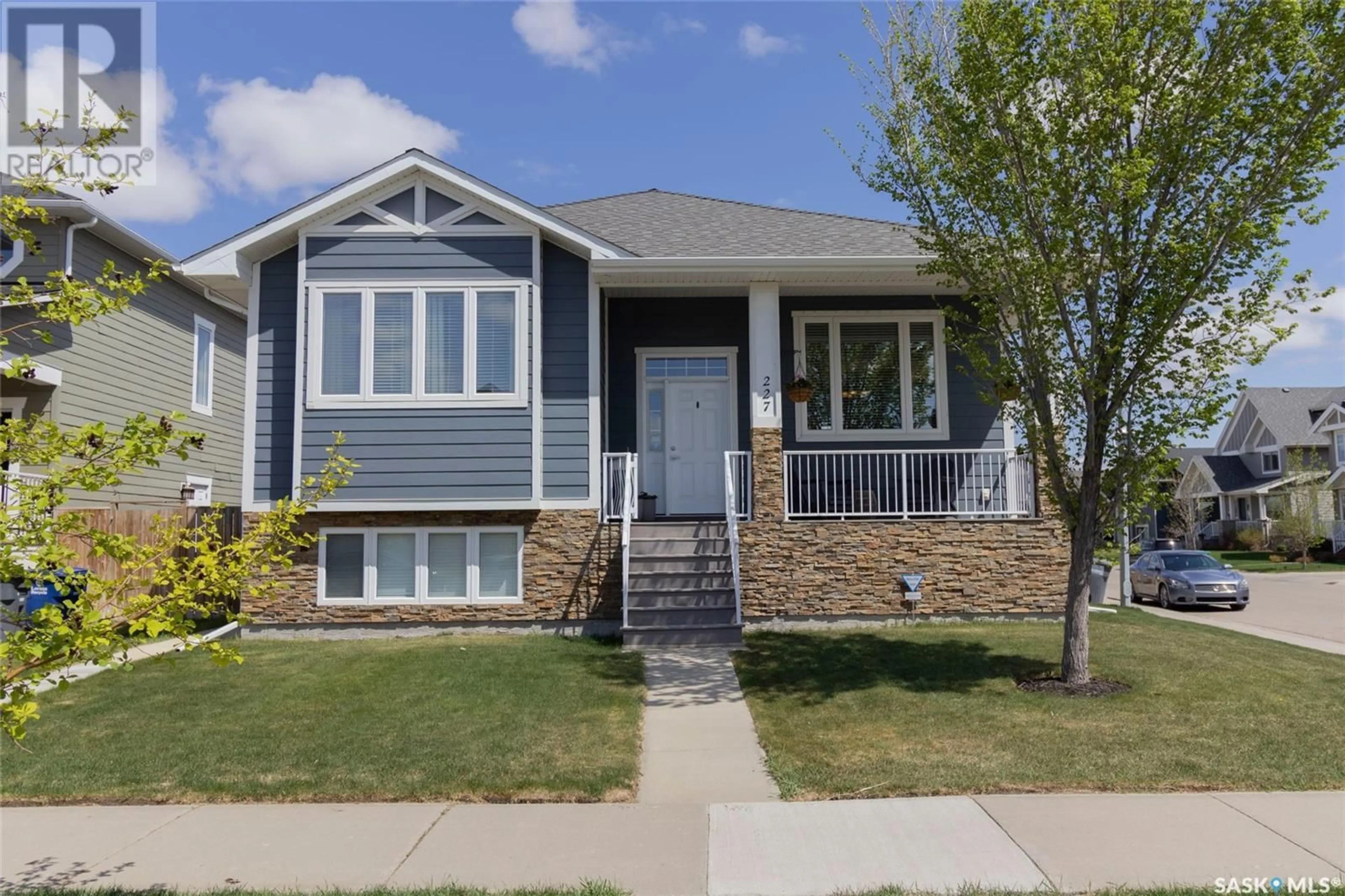 Home with vinyl exterior material, street for 227 MEADOWS BOULEVARD, Saskatoon Saskatchewan S7V0E9