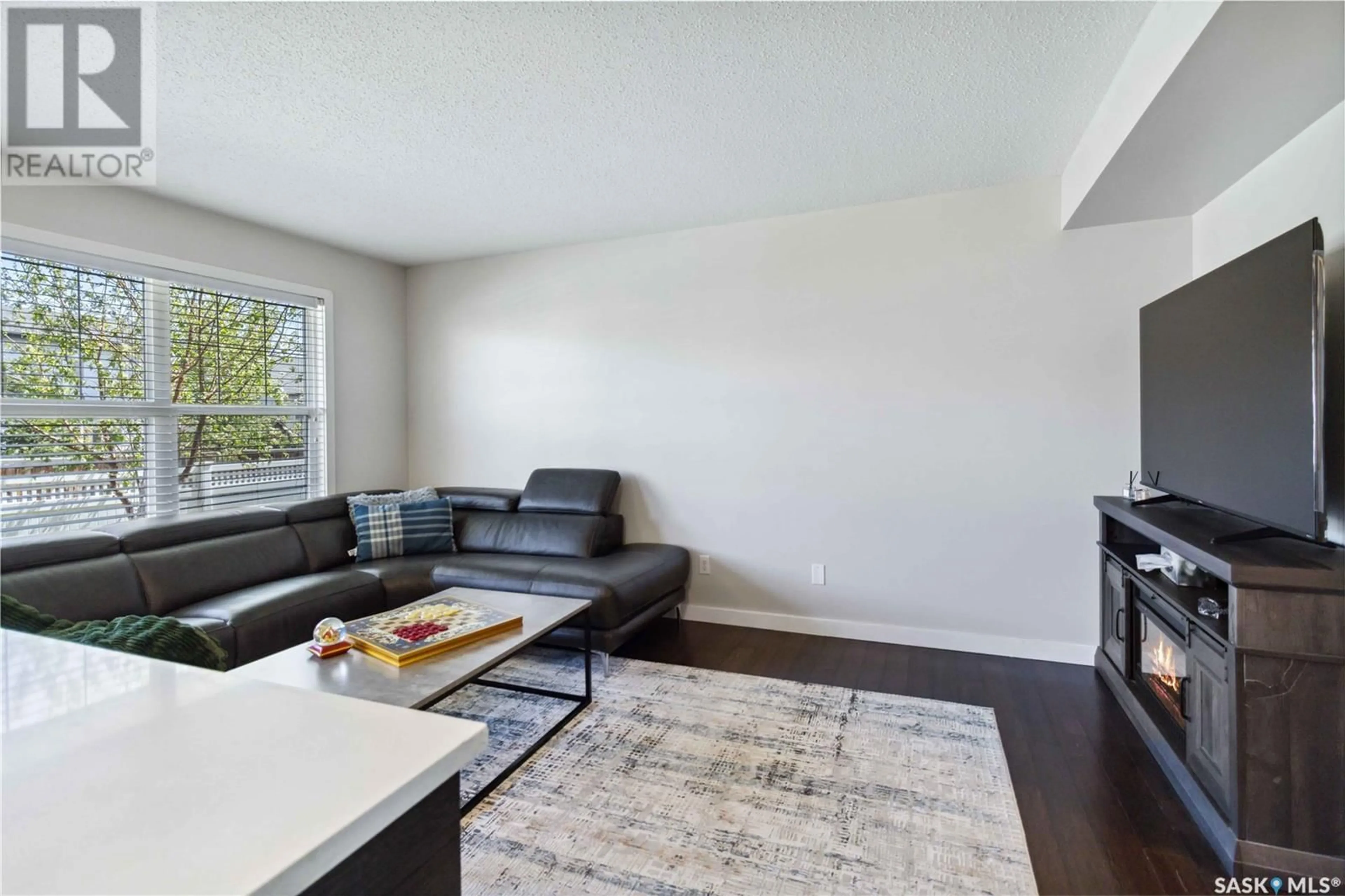 Living room with furniture, wood/laminate floor for 410 - 312 LEDINGHAM WAY, Saskatoon Saskatchewan S7V0C4