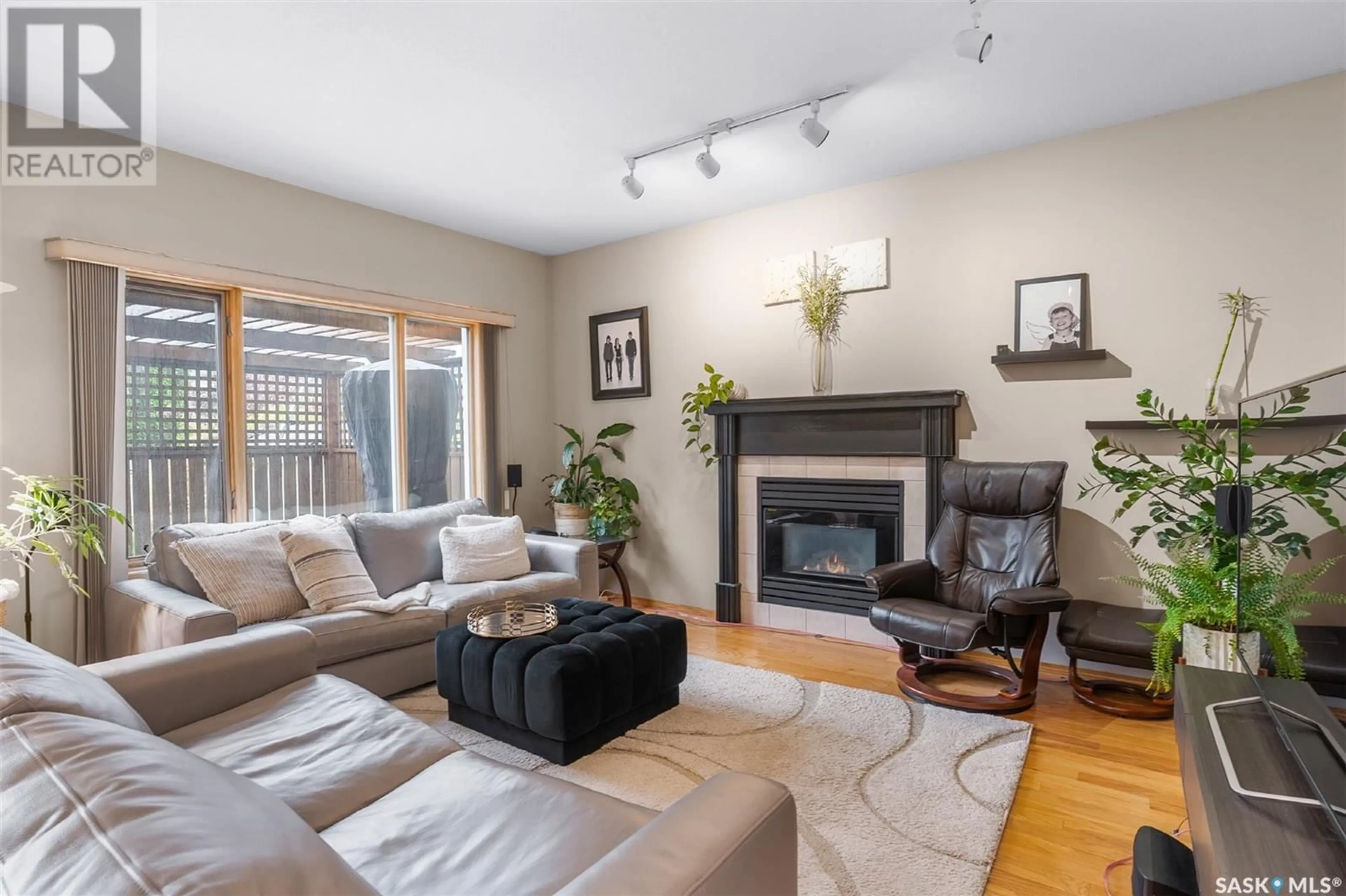 Living room with furniture, wood/laminate floor for 138 EASTMAN COVE, Saskatoon Saskatchewan S7N4K9