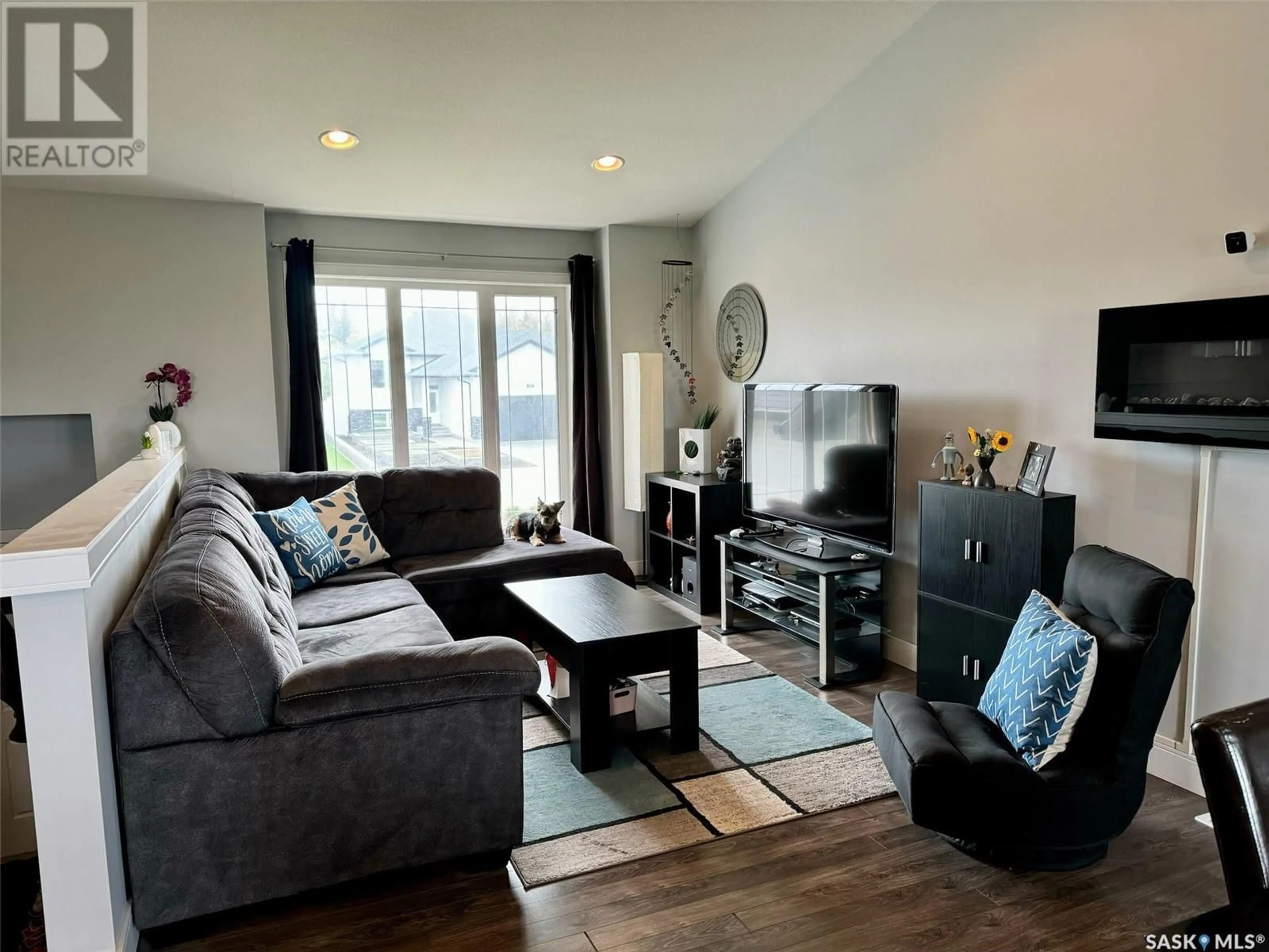 Living room with furniture, wood/laminate floor for 116 OLAUSON CRESCENT, Vanscoy Saskatchewan S0L3J0