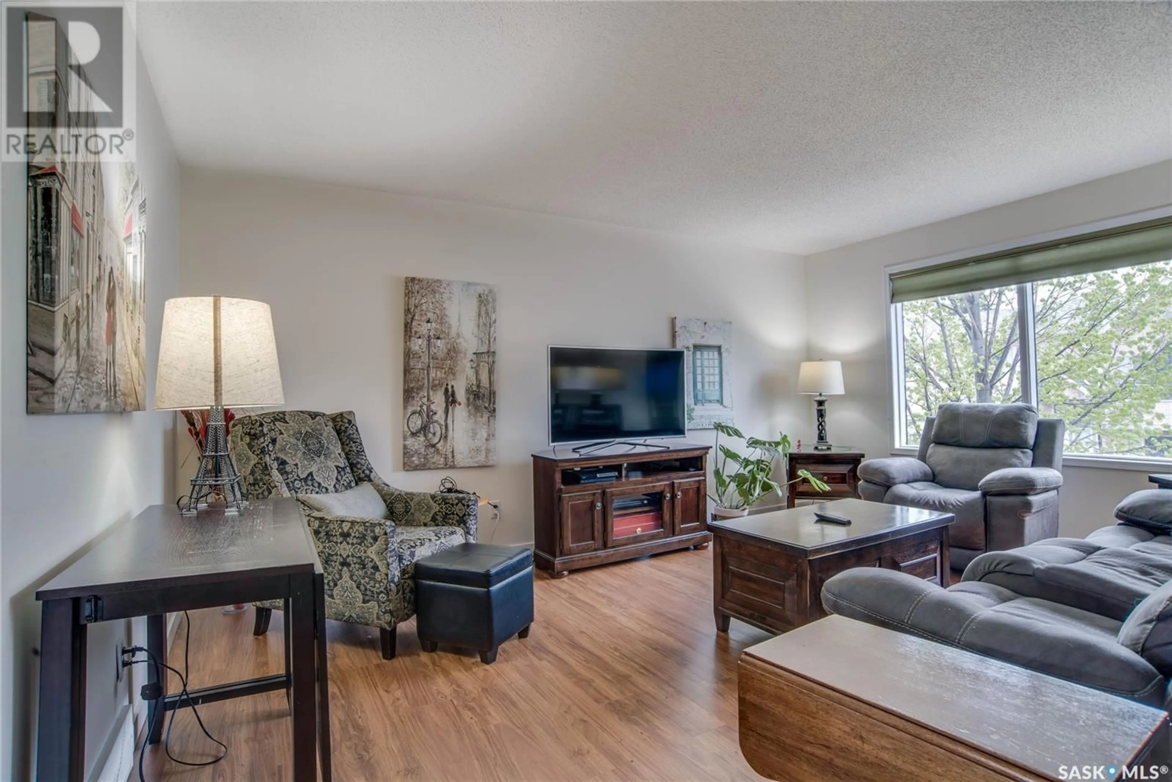 Living room with furniture, wood/laminate floor for 306 - 610 PEREHUDOFF CRESCENT, Saskatoon Saskatchewan S7H4H5