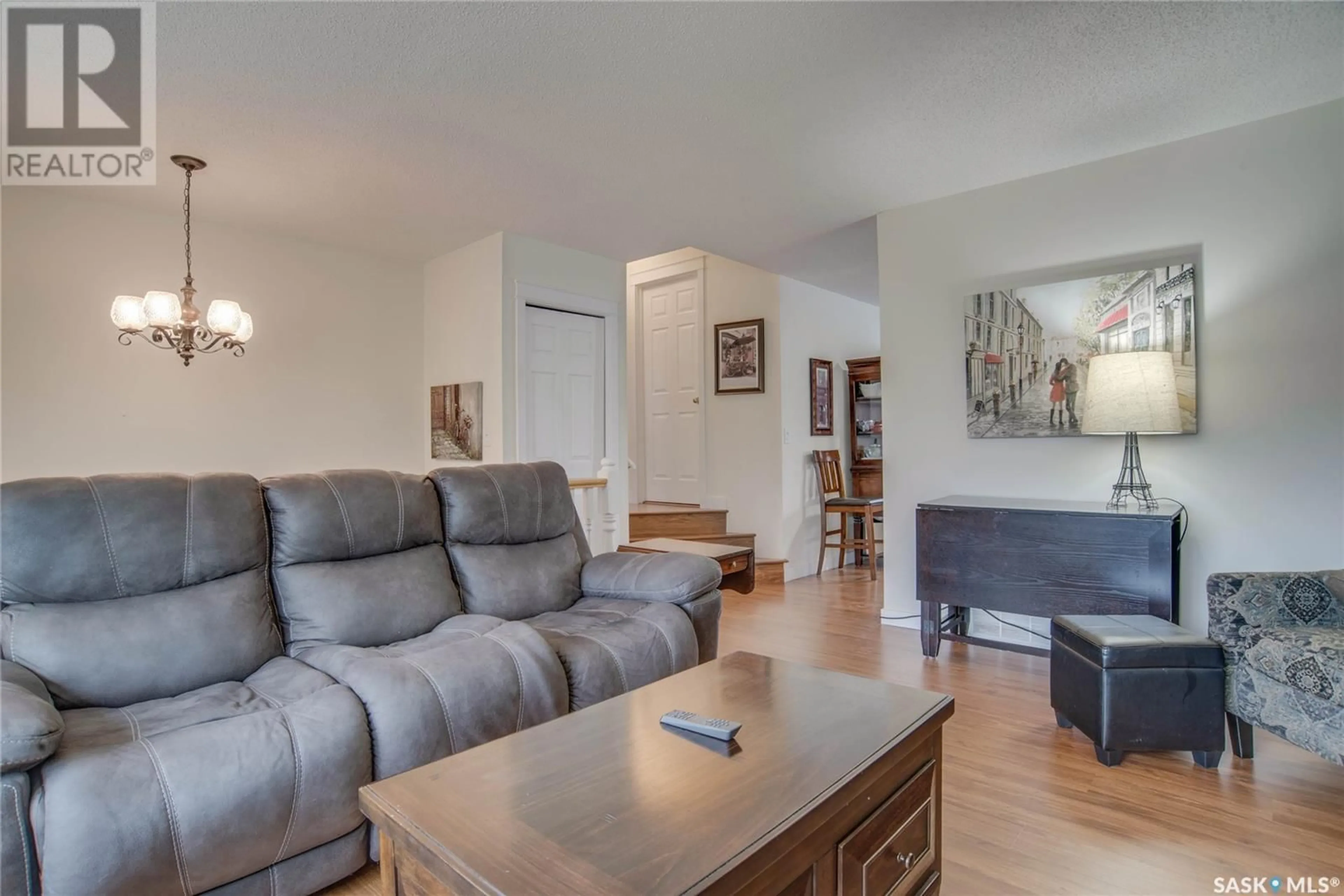 Living room with furniture, wood/laminate floor for 306 - 610 PEREHUDOFF CRESCENT, Saskatoon Saskatchewan S7H4H5