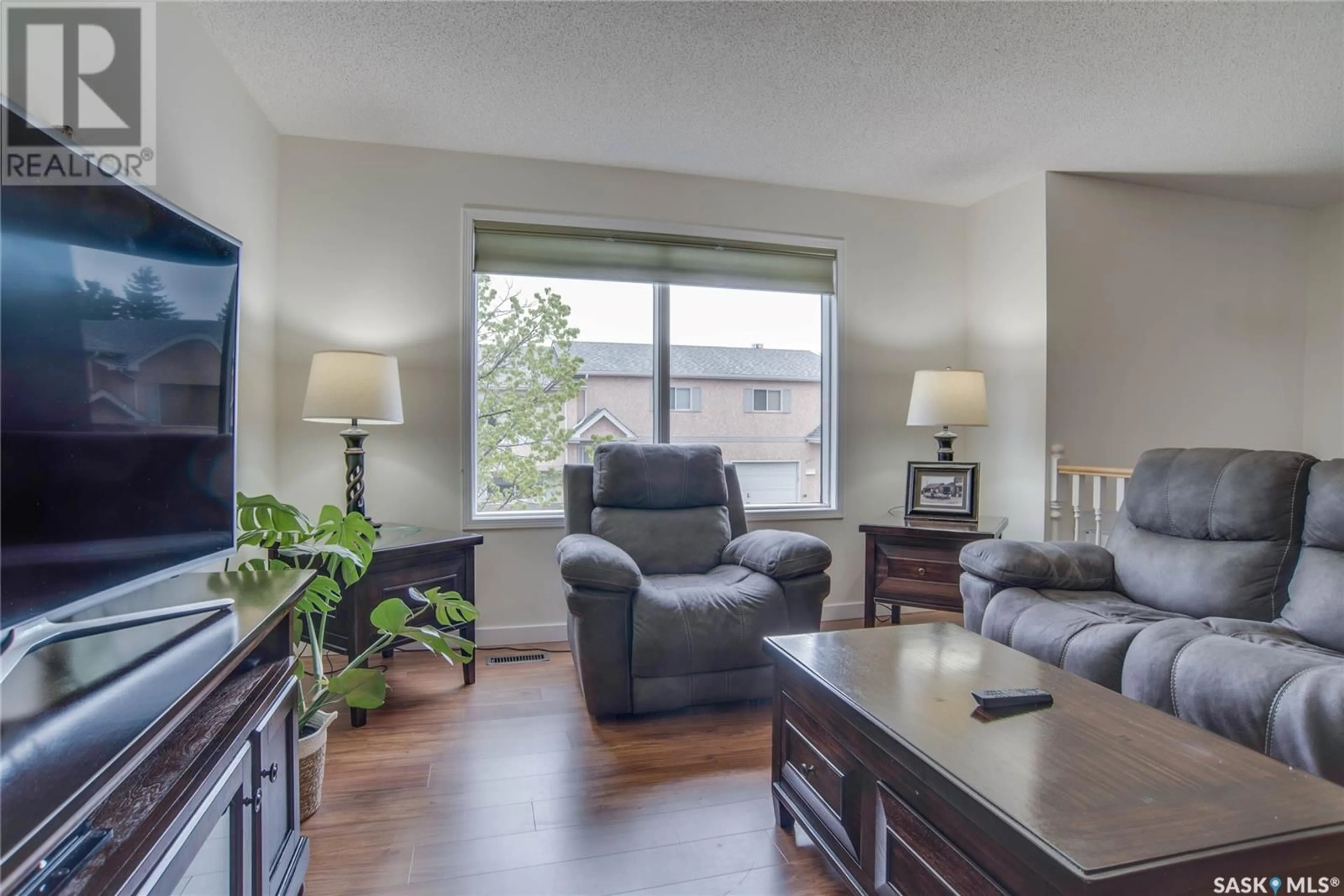 Living room with furniture, wood/laminate floor for 306 - 610 PEREHUDOFF CRESCENT, Saskatoon Saskatchewan S7H4H5