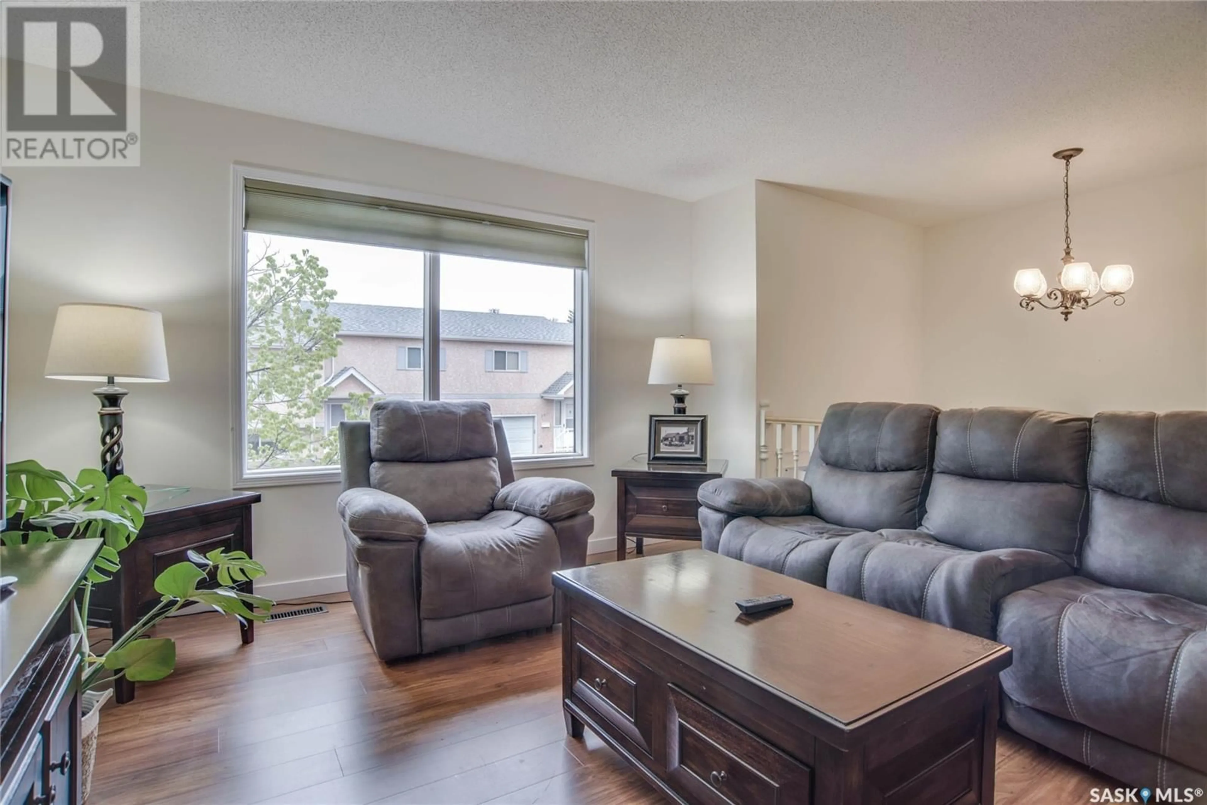 Living room with furniture, wood/laminate floor for 306 - 610 PEREHUDOFF CRESCENT, Saskatoon Saskatchewan S7H4H5