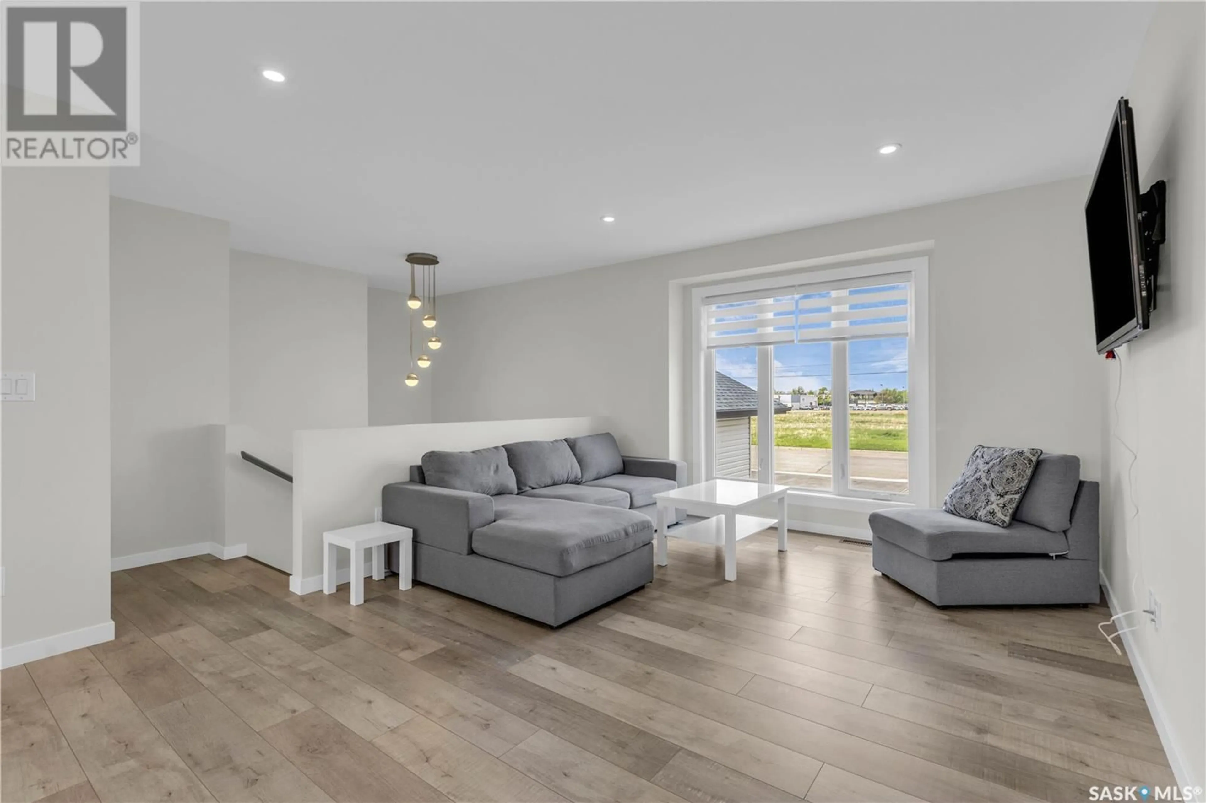 Living room with furniture, wood/laminate floor for 2582 100TH STREET, North Battleford Saskatchewan S9A0Y2