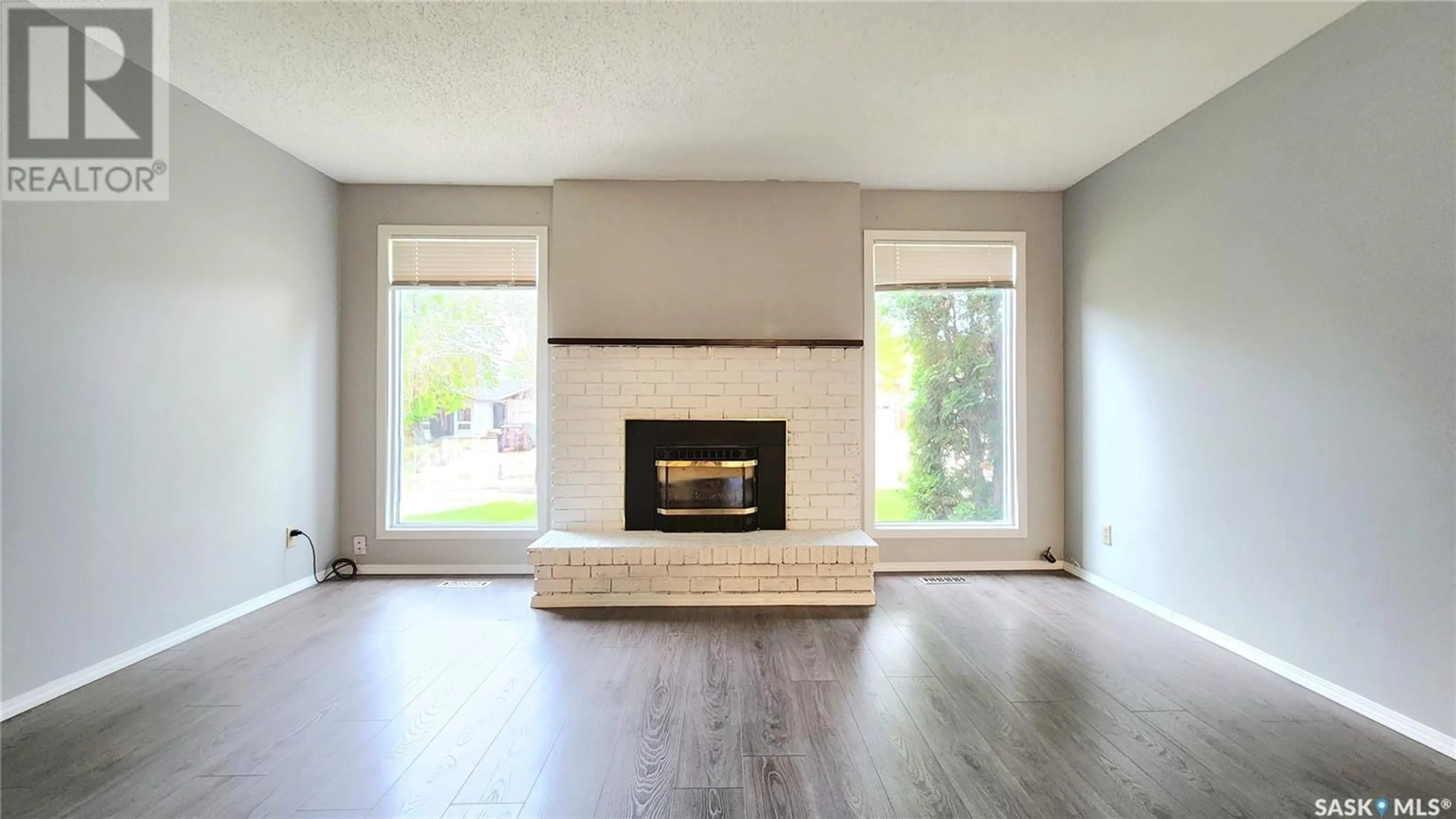 Living room with furniture, wood/laminate floor for 10716 MEIGHEN CRESCENT, North Battleford Saskatchewan S9A3L1