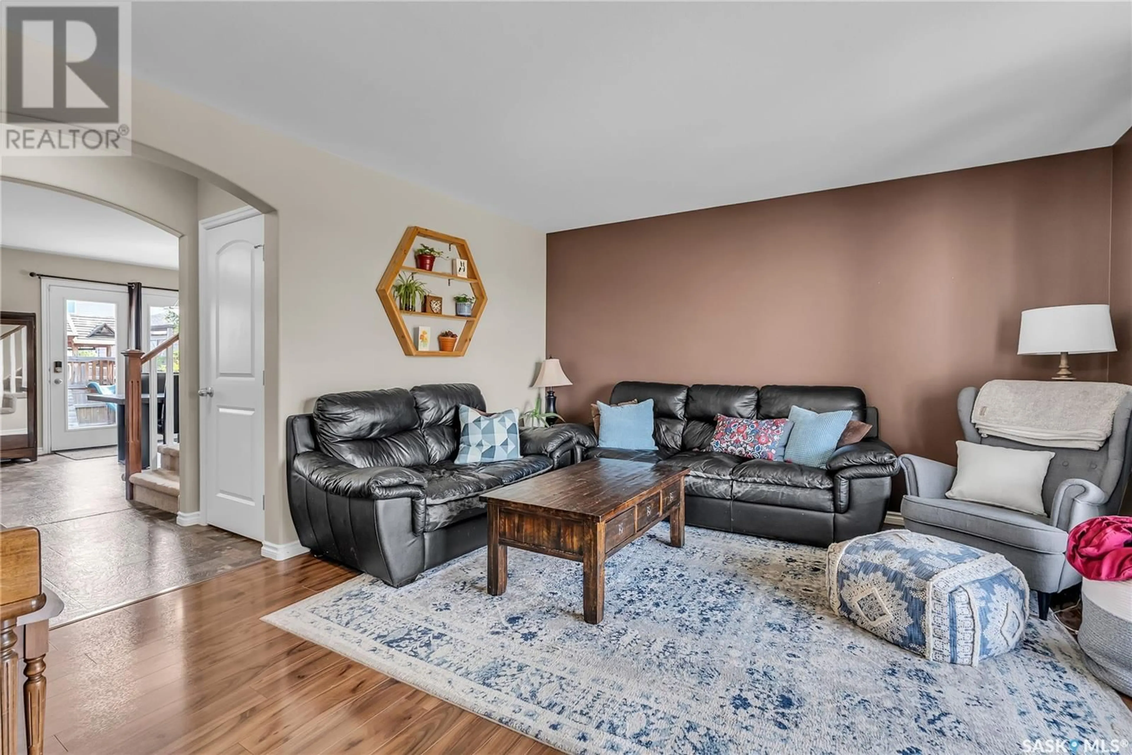 Living room with furniture, wood/laminate floor for 174 CORNISH ROAD, Saskatoon Saskatchewan S7K0K4