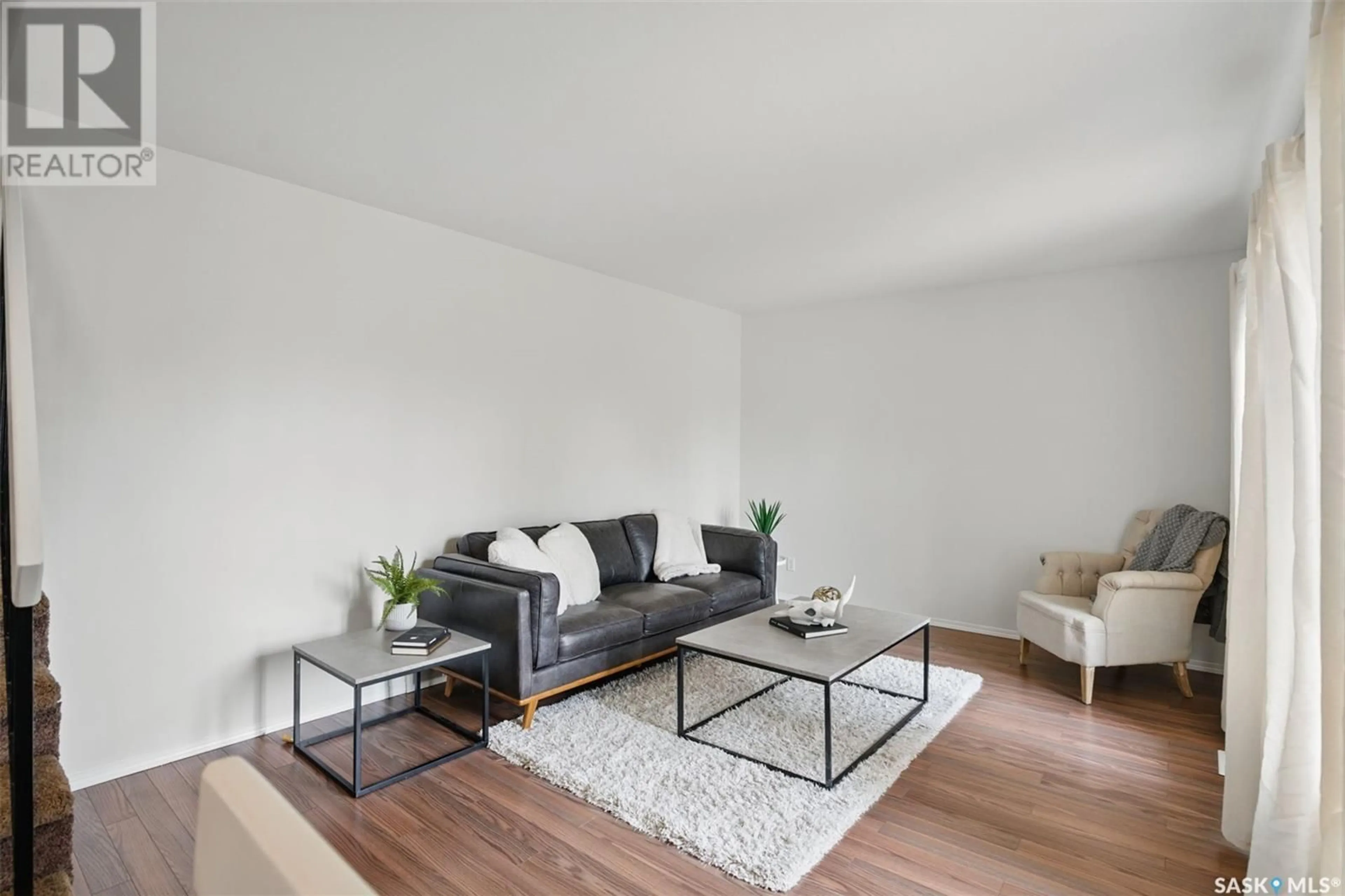 Living room with furniture, wood/laminate floor for 3827 TAYLOR STREET, Saskatoon Saskatchewan S7H5J4