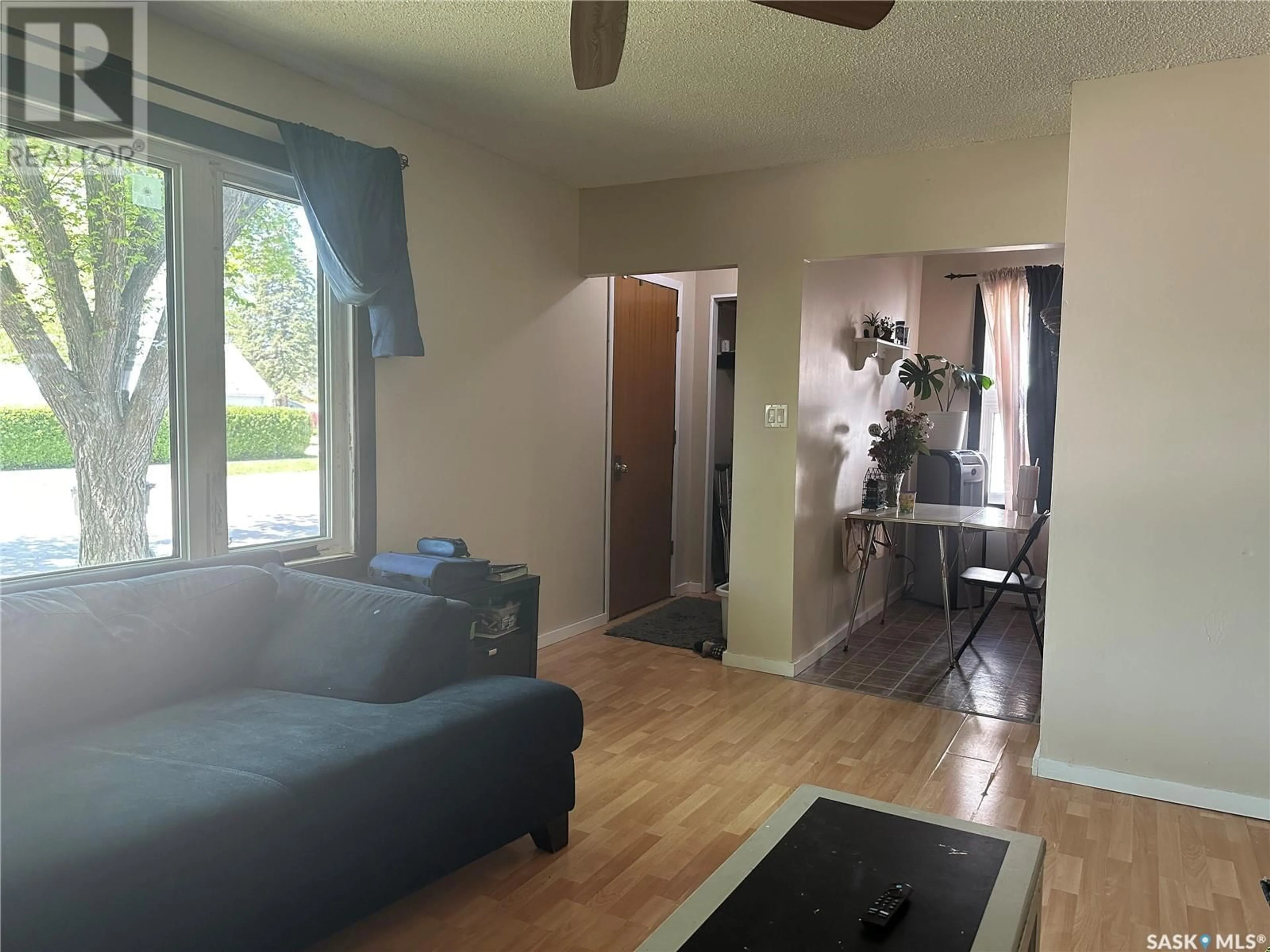 Living room with furniture, wood/laminate floor for 102 9TH STREET, Weyburn Saskatchewan S4H1E7
