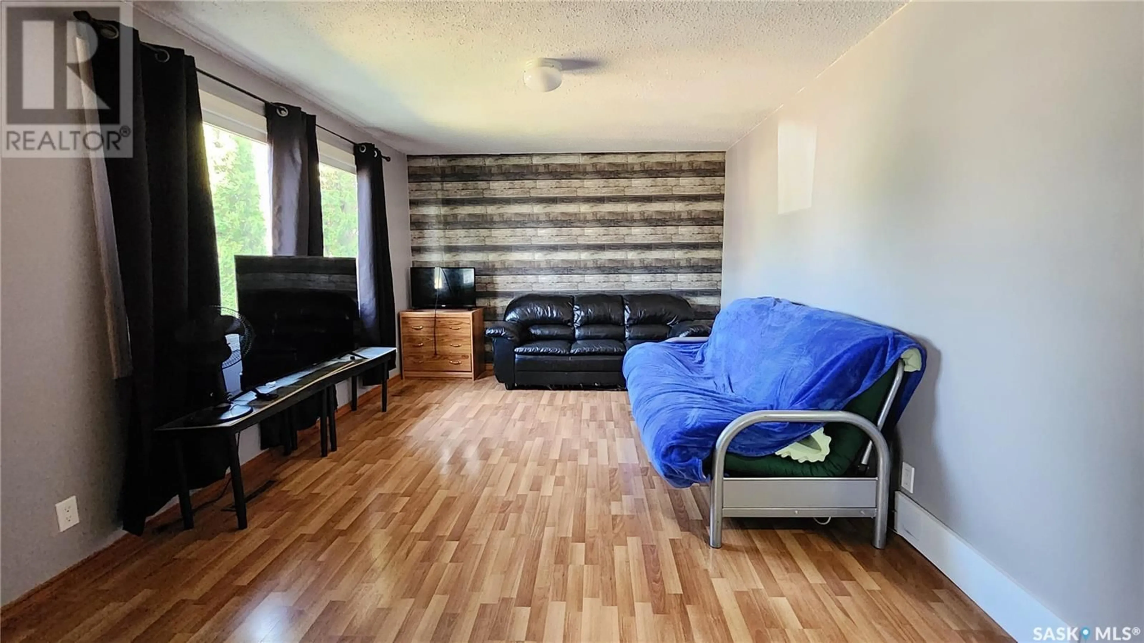 Living room with furniture, wood/laminate floor for 1432 112TH STREET, North Battleford Saskatchewan S9A3B2