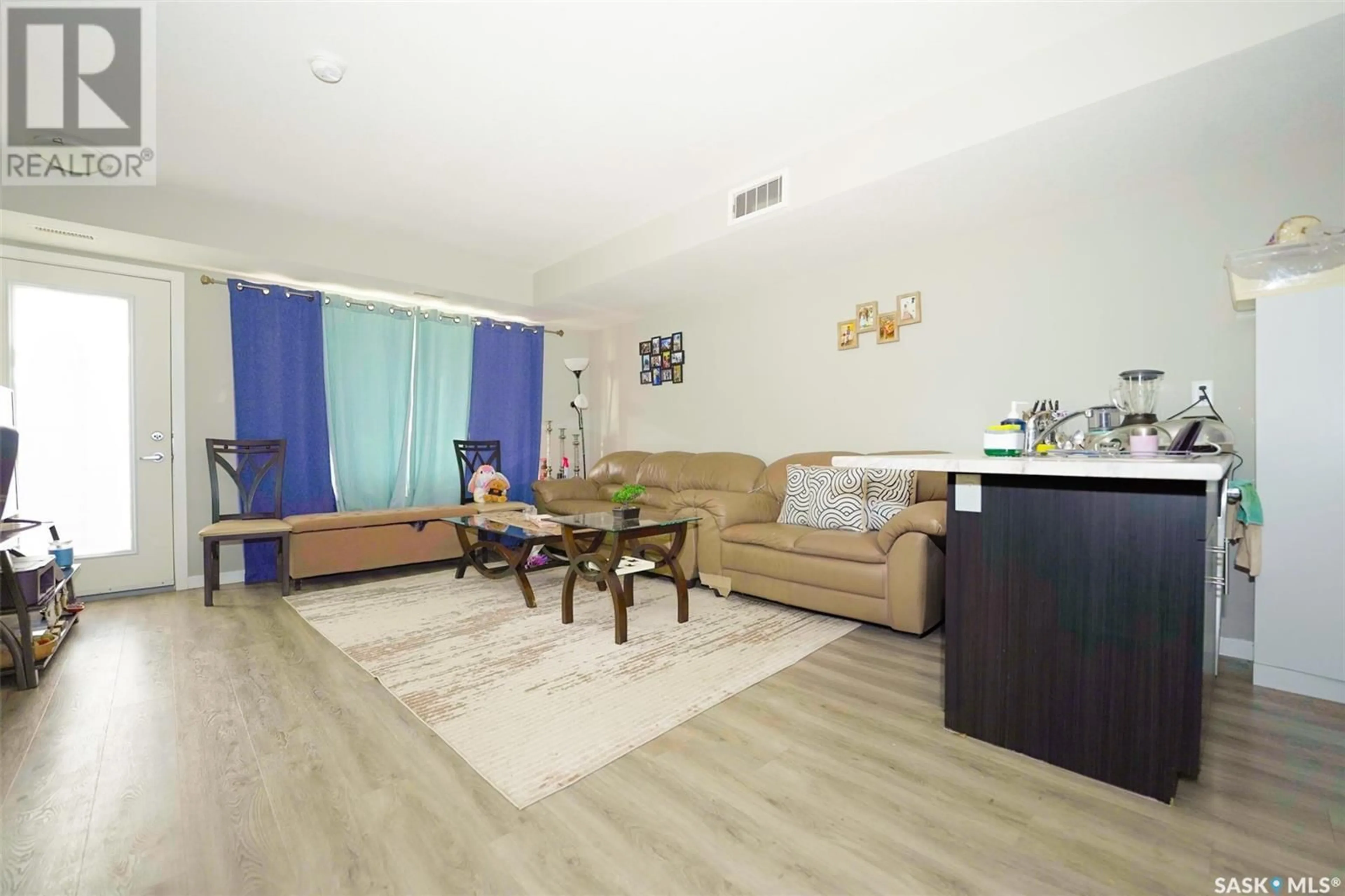 Living room with furniture, wood/laminate floor for 307B - 3355 GREEN POPPY STREET, Regina Saskatchewan S4V3P6