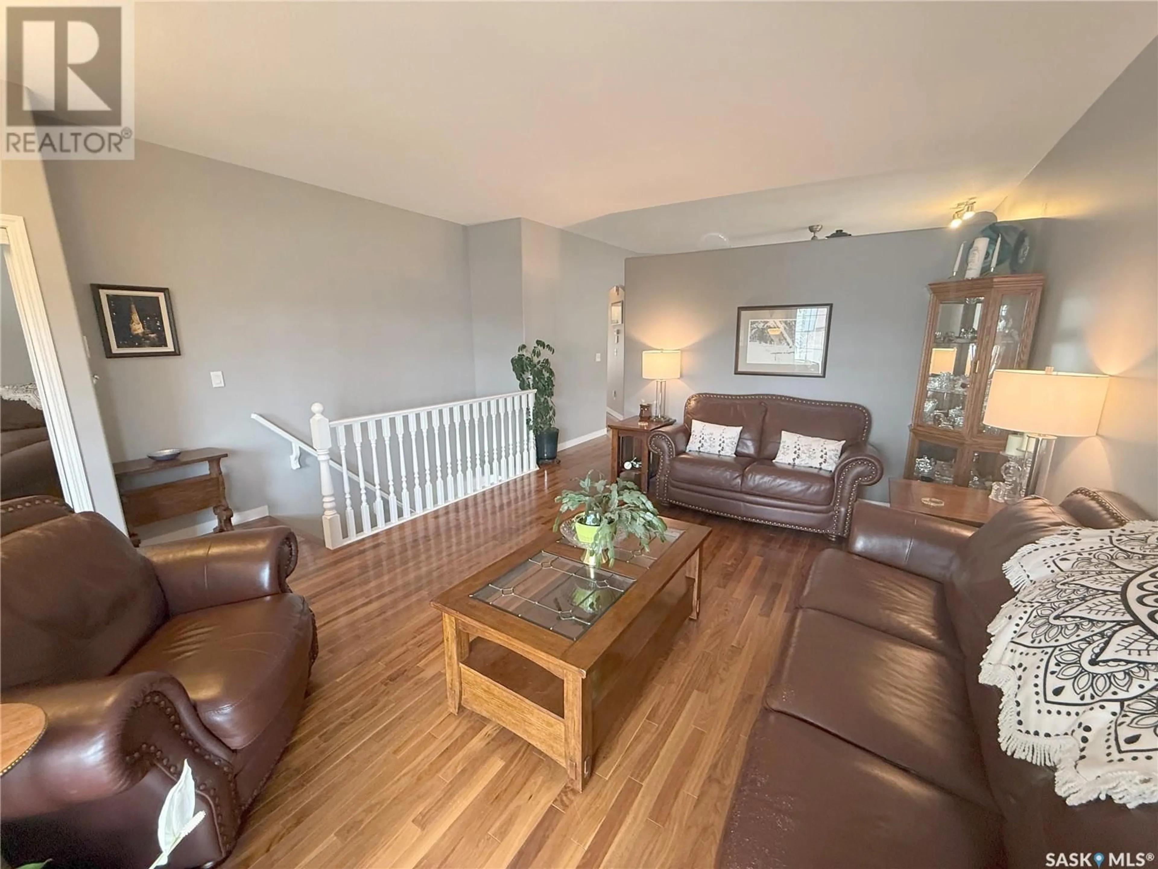 Living room with furniture, wood/laminate floor for 767 SANDSTONE TERRACE, Martensville Saskatchewan S0K2T2
