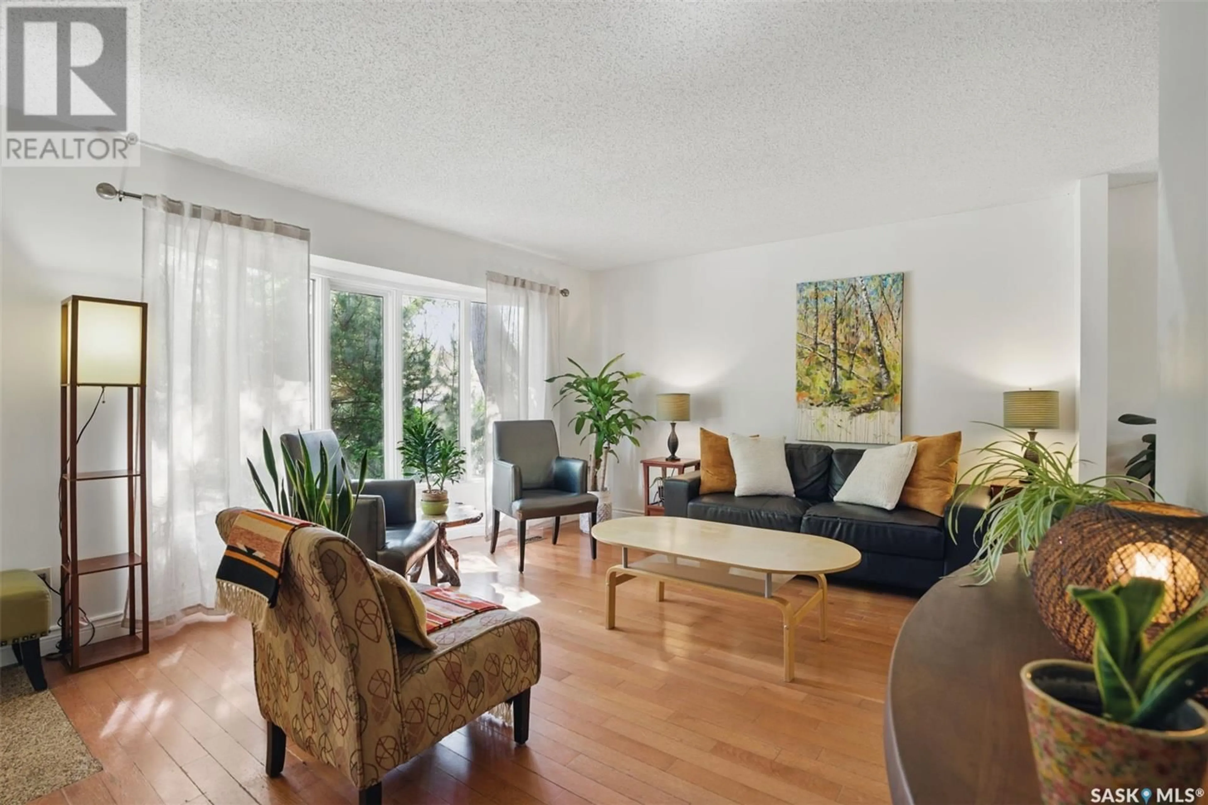 Living room with furniture, wood/laminate floor for 231 KENOSEE CRESCENT, Saskatoon Saskatchewan S7J3T1
