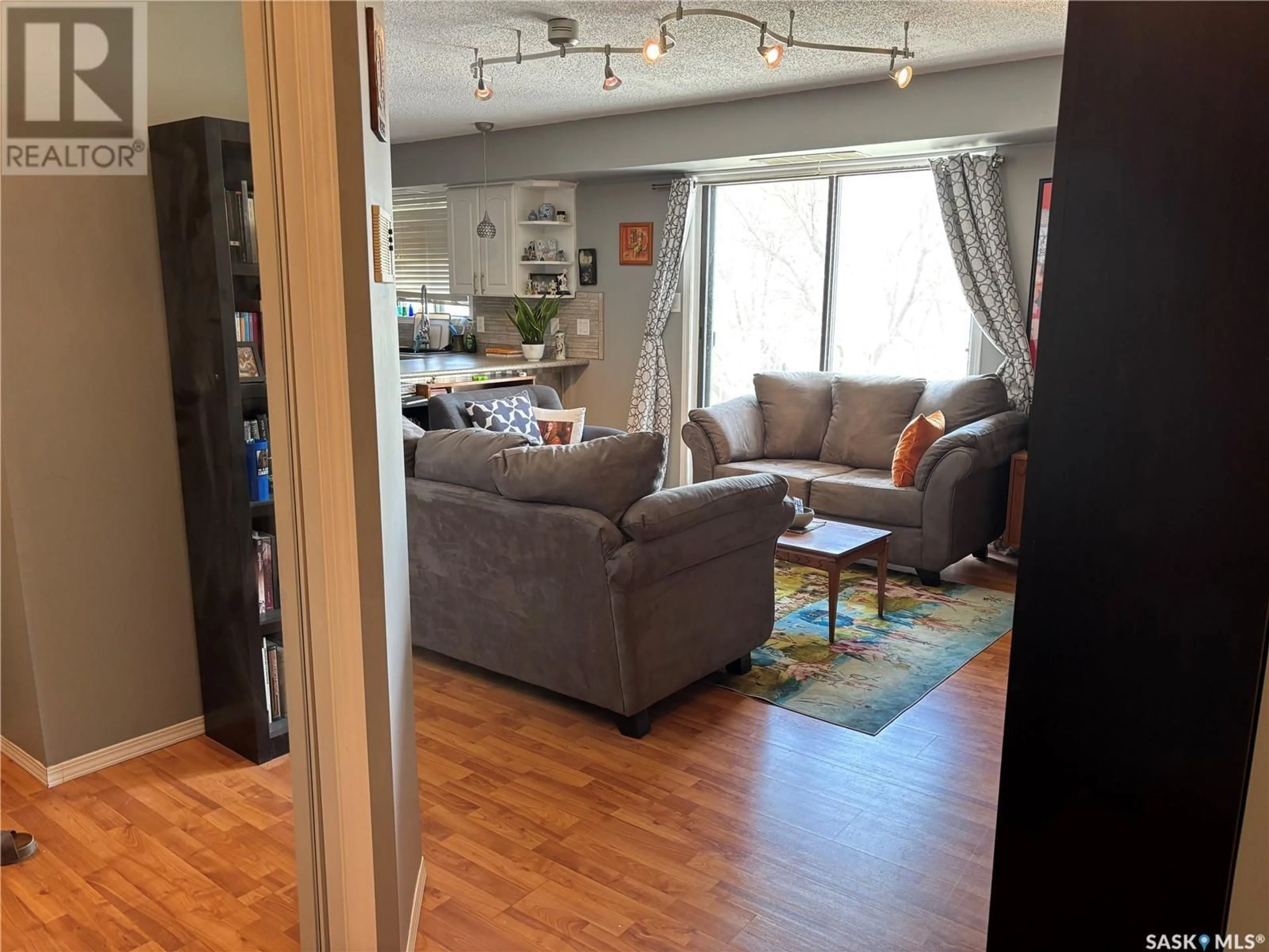 Living room with furniture, wood/laminate floor for 302 2315 MCINTYRE STREET, Regina Saskatchewan S4P3Y8