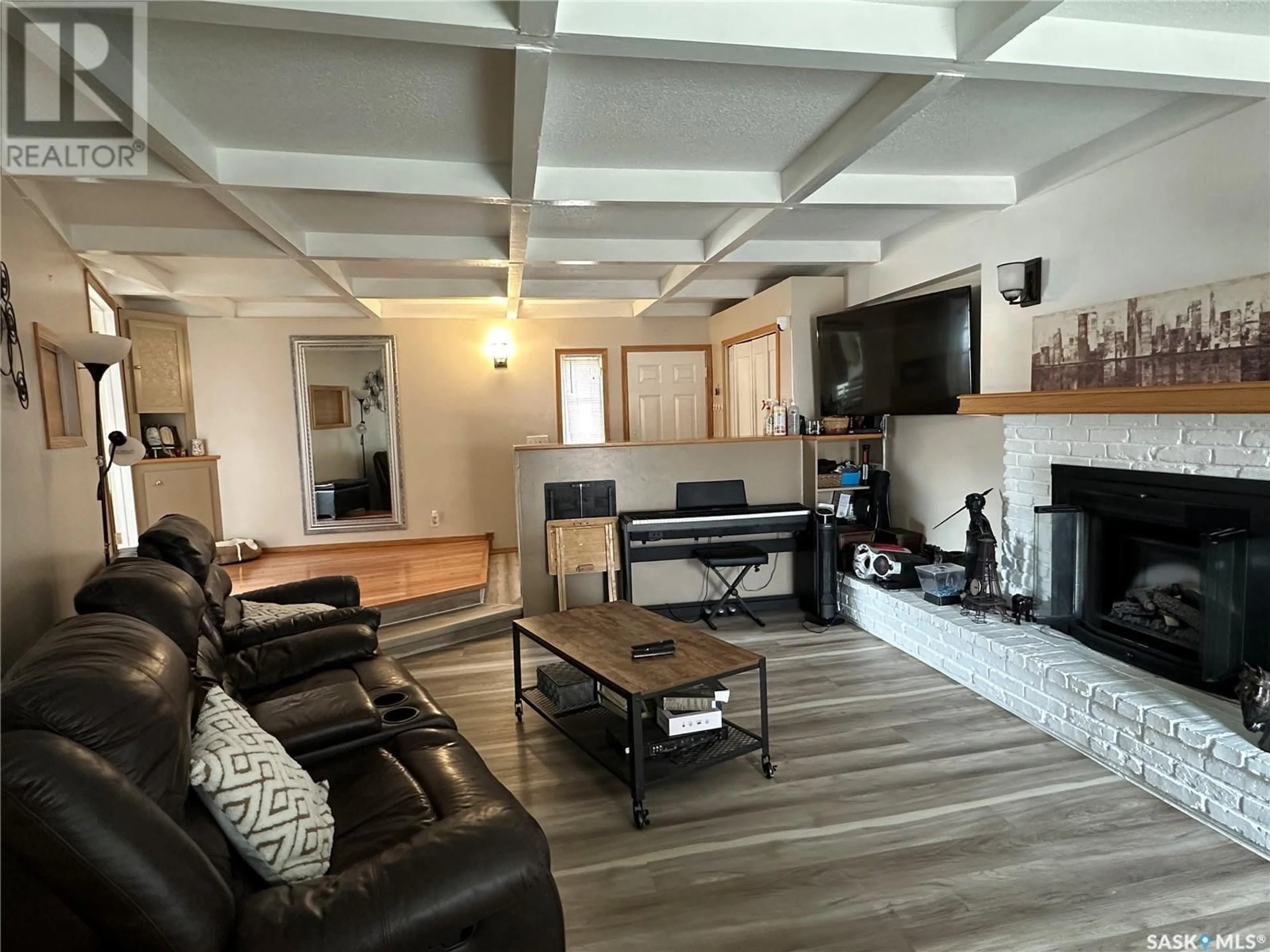 Living room with furniture, wood/laminate floor for 129 BIRCH DRIVE, Weyburn Saskatchewan S4H0S6