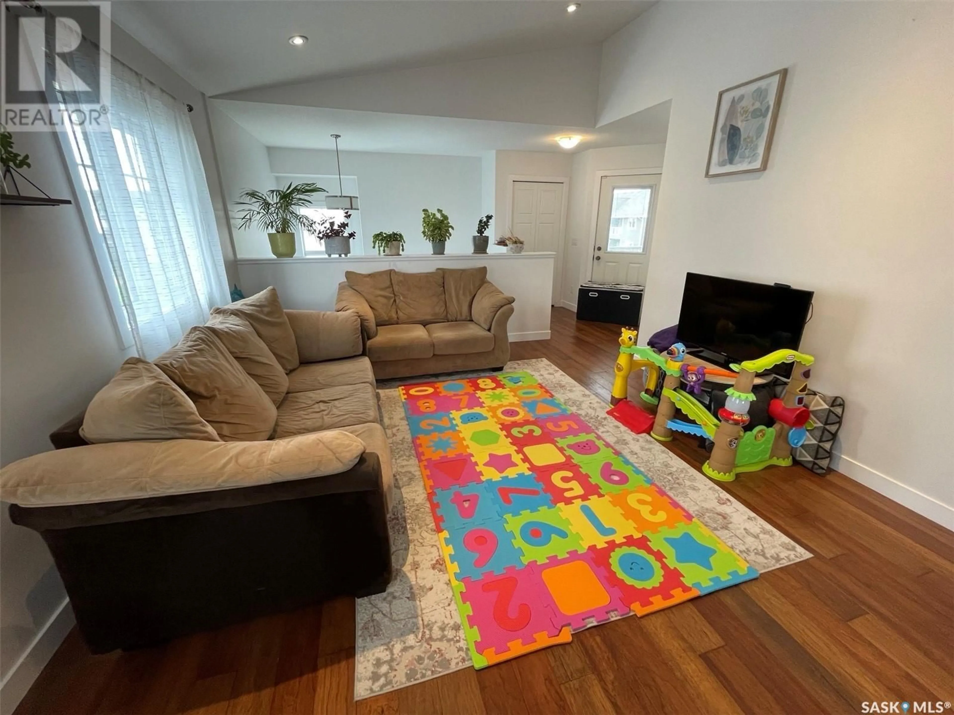 Living room with furniture, wood/laminate floor for 4267 GREEN APPLE DRIVE, Regina Saskatchewan S4V1M6