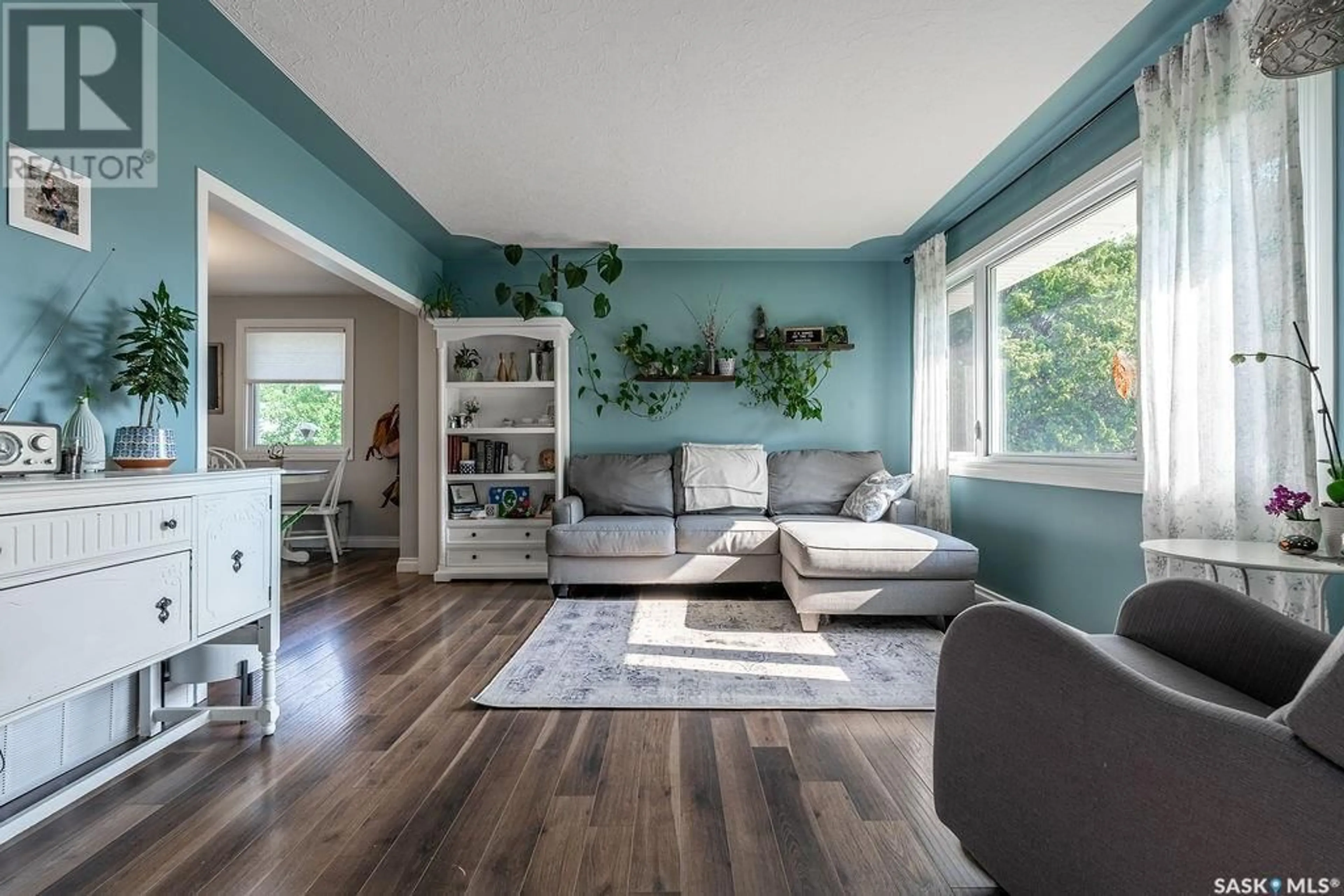 Living room with furniture, wood/laminate floor for 2236 EWART AVENUE, Saskatoon Saskatchewan S7J1Y2