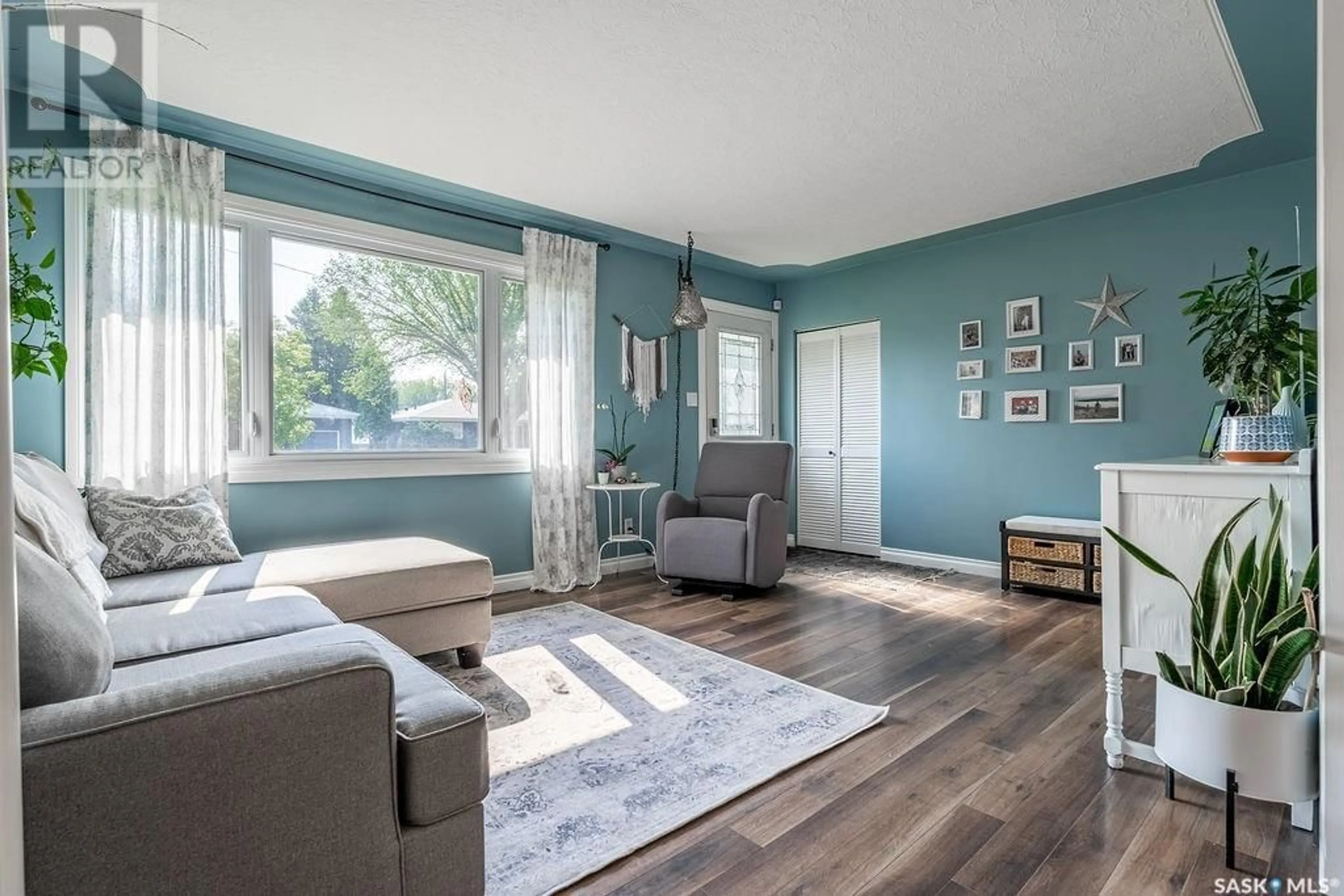 Living room with furniture, wood/laminate floor for 2236 EWART AVENUE, Saskatoon Saskatchewan S7J1Y2