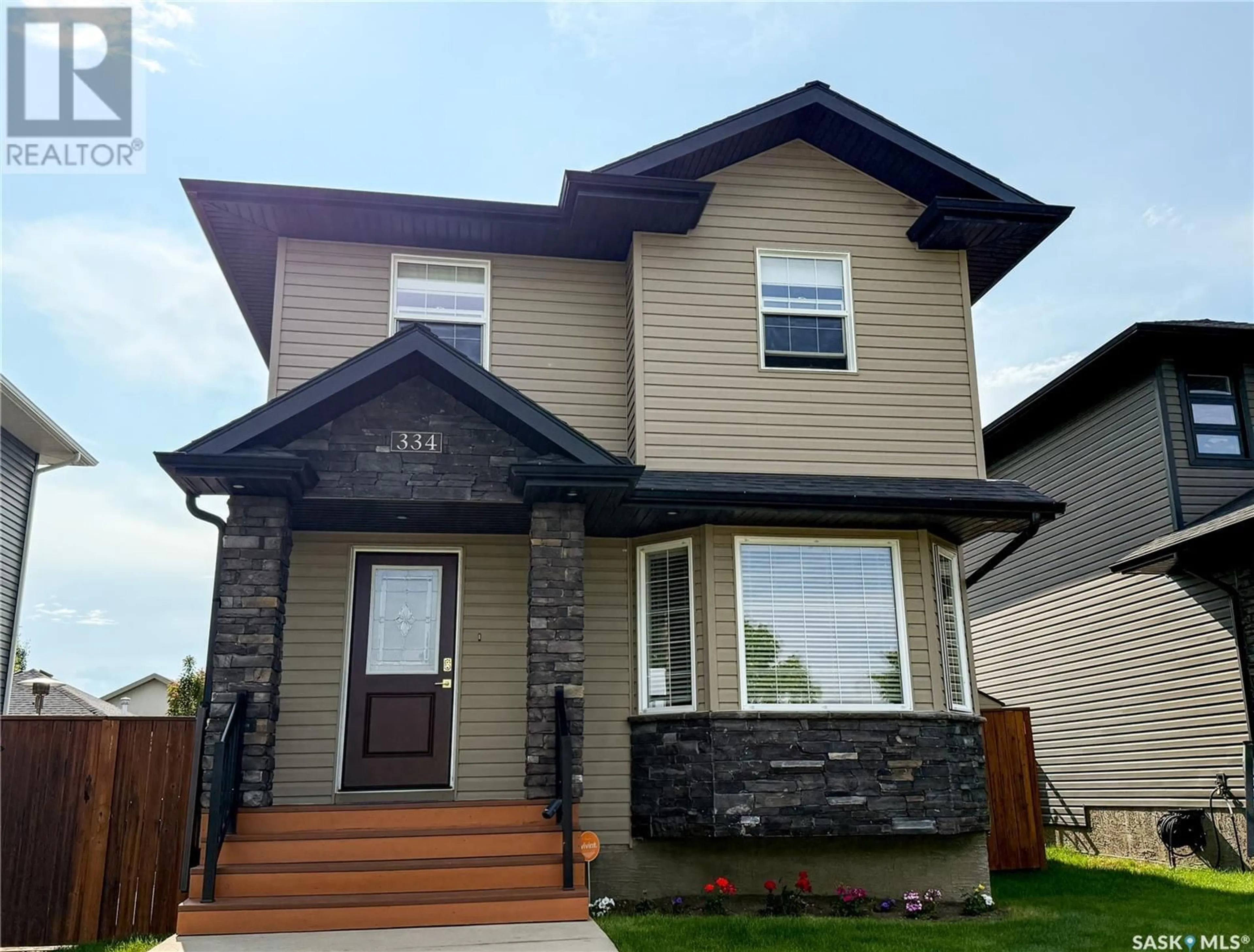Home with vinyl exterior material, street for 334 STONEBRIDGE COMMON, Saskatoon Saskatchewan S7T0H2