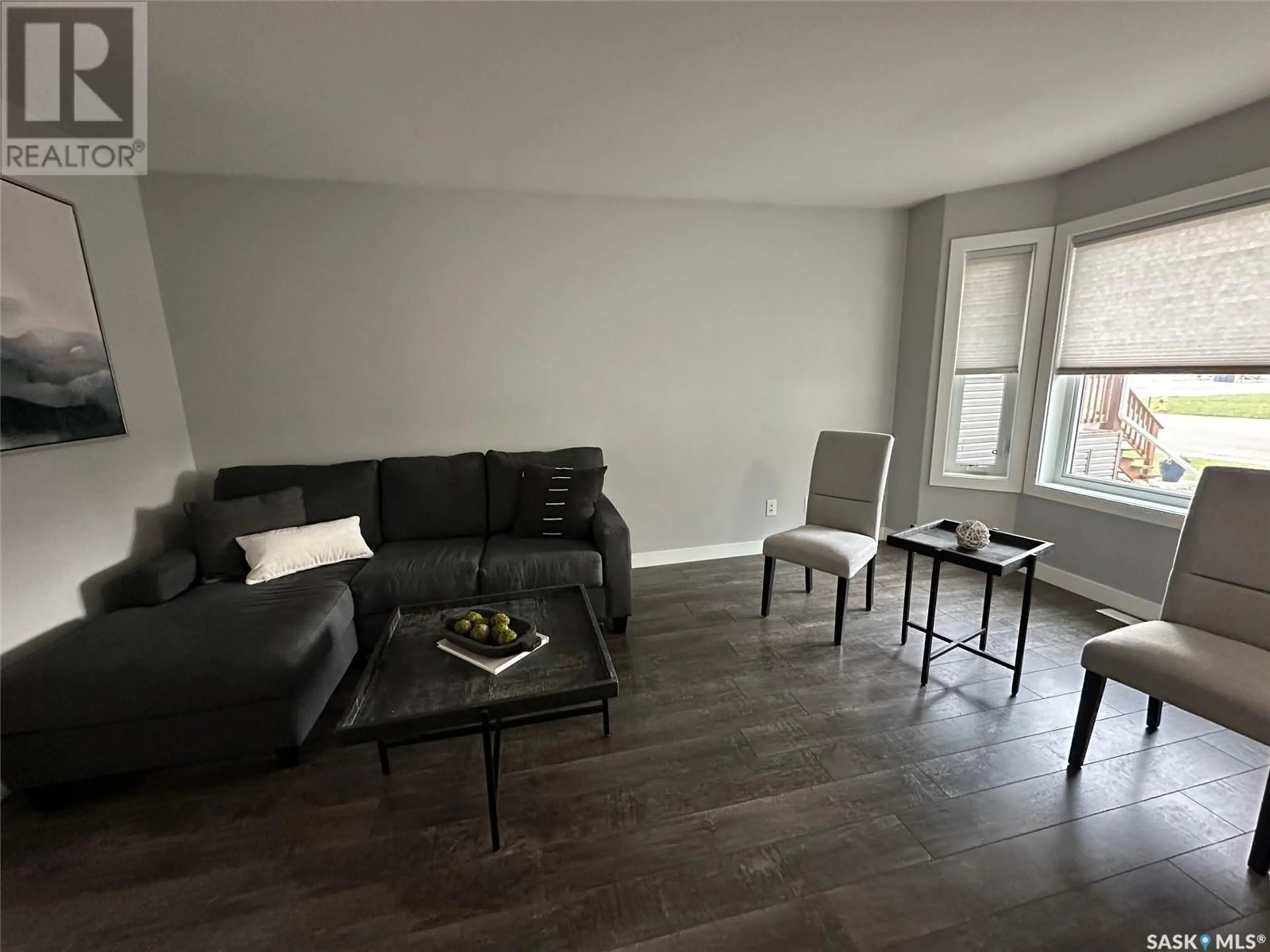 Living room with furniture, wood/laminate floor for 408 SILLERS STREET, Estevan Saskatchewan S4A2Y9