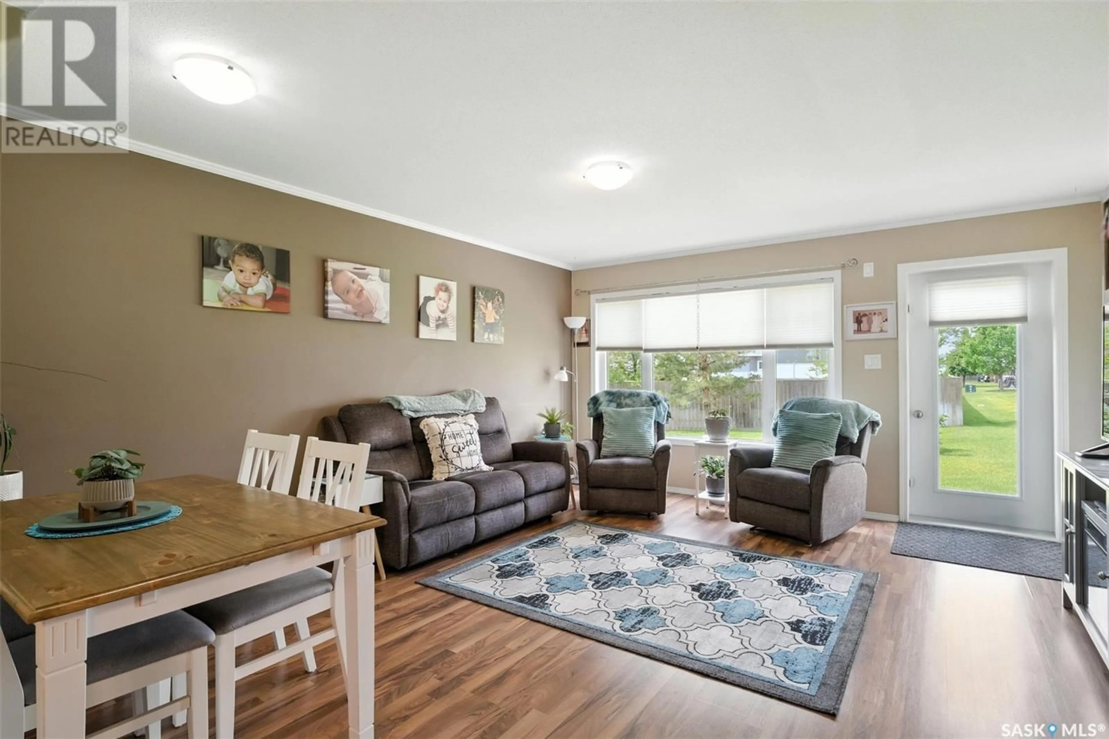 Living room with furniture, wood/laminate floor for 715 - 803 HART ROAD, Saskatoon Saskatchewan S7M3Y7