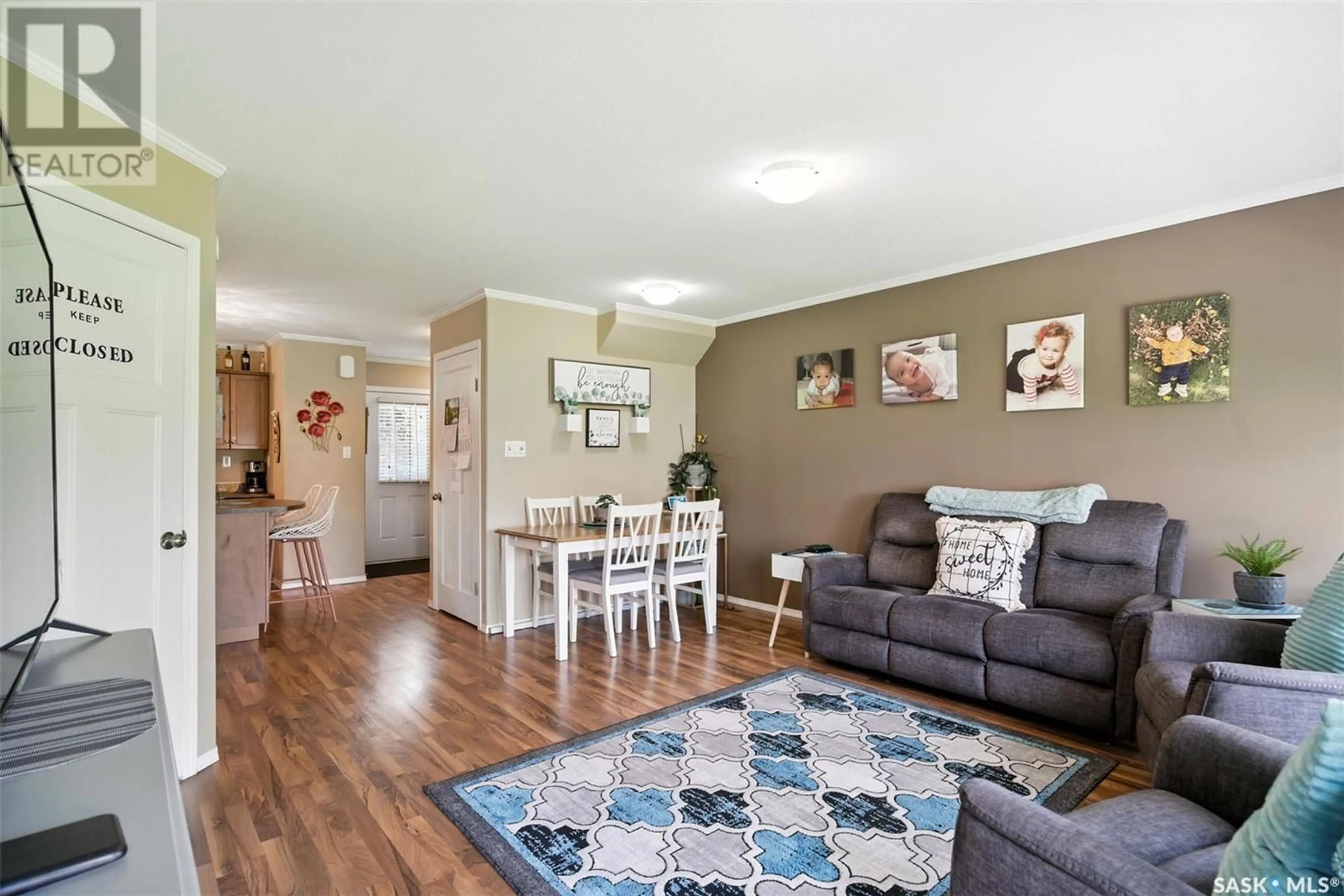 Living room with furniture, wood/laminate floor for 715 - 803 HART ROAD, Saskatoon Saskatchewan S7M3Y7