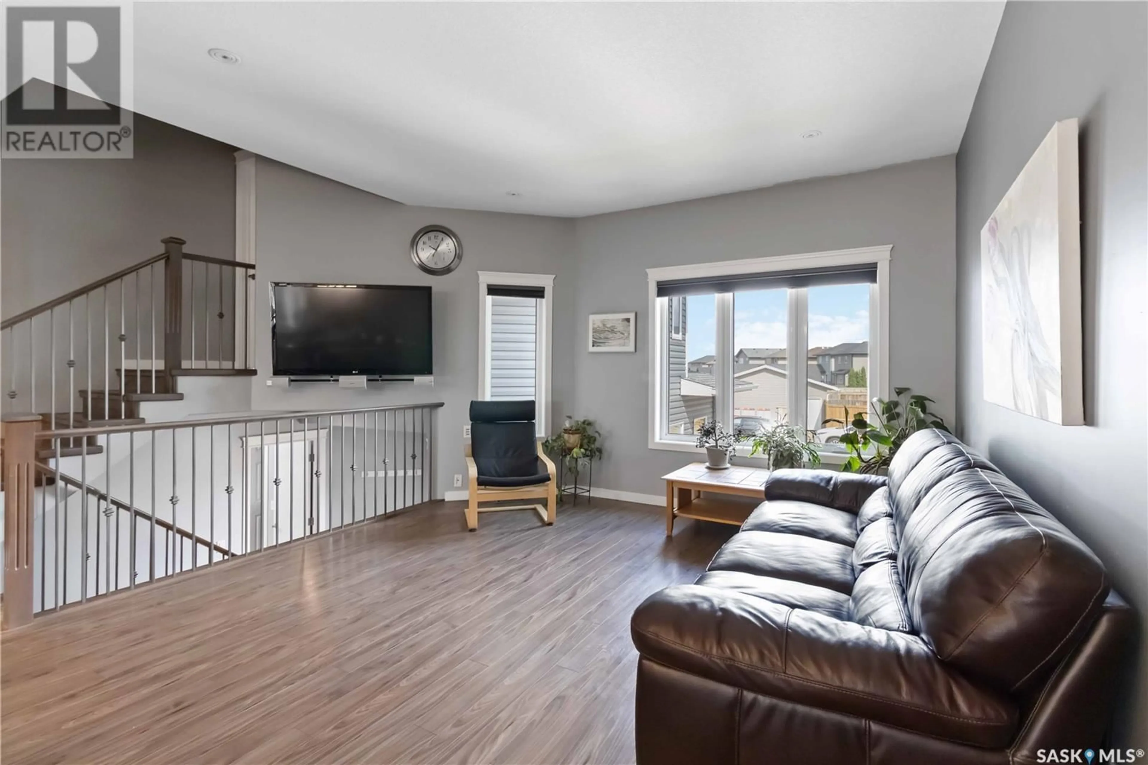 Living room with furniture, wood/laminate floor for 1011 KLOPPENBURG BEND, Saskatoon Saskatchewan S7W0P4
