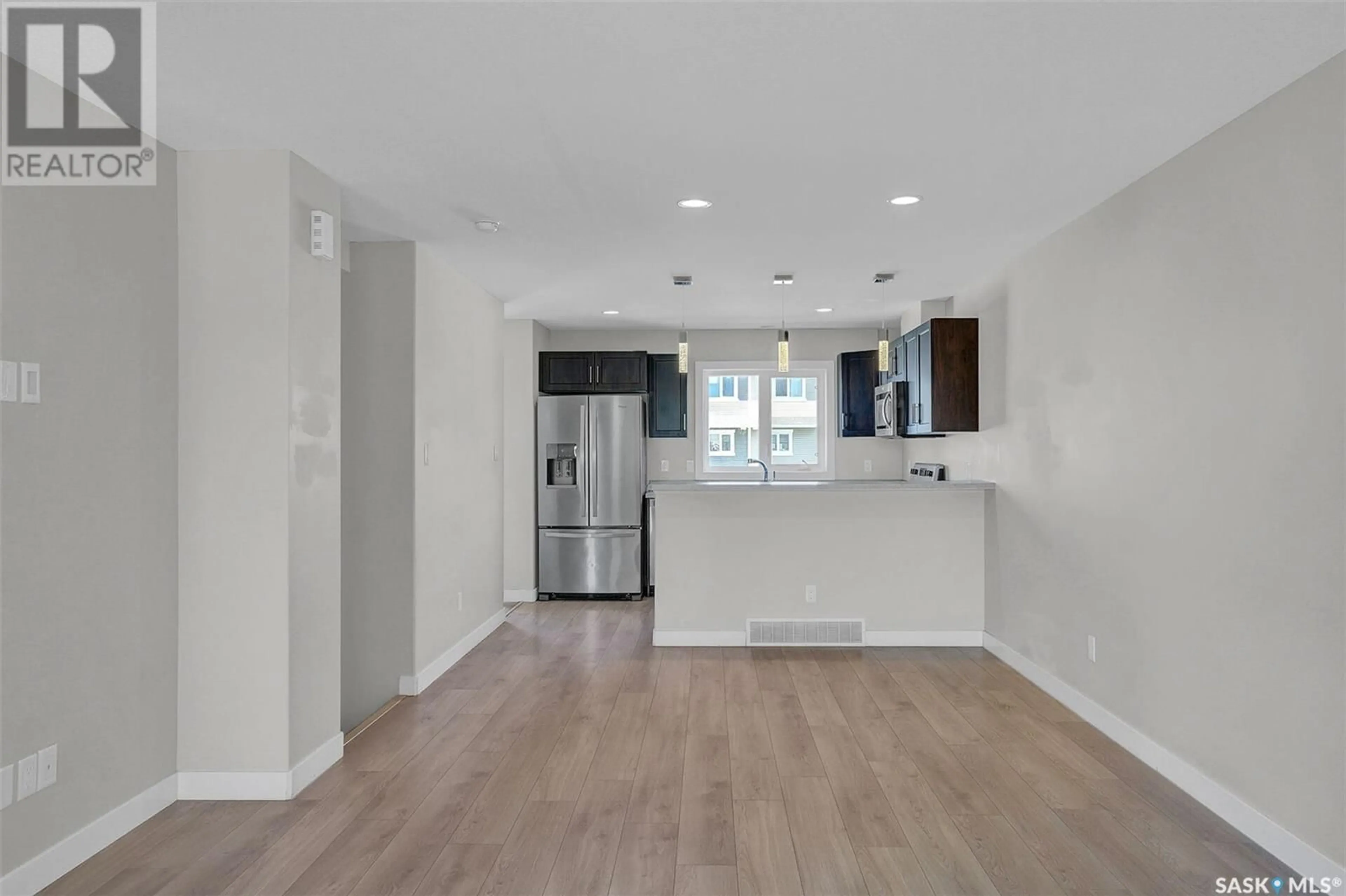 Open concept kitchen, wood/laminate floor for 5648 PREFONTAINE AVENUE, Regina Saskatchewan S4W0M8