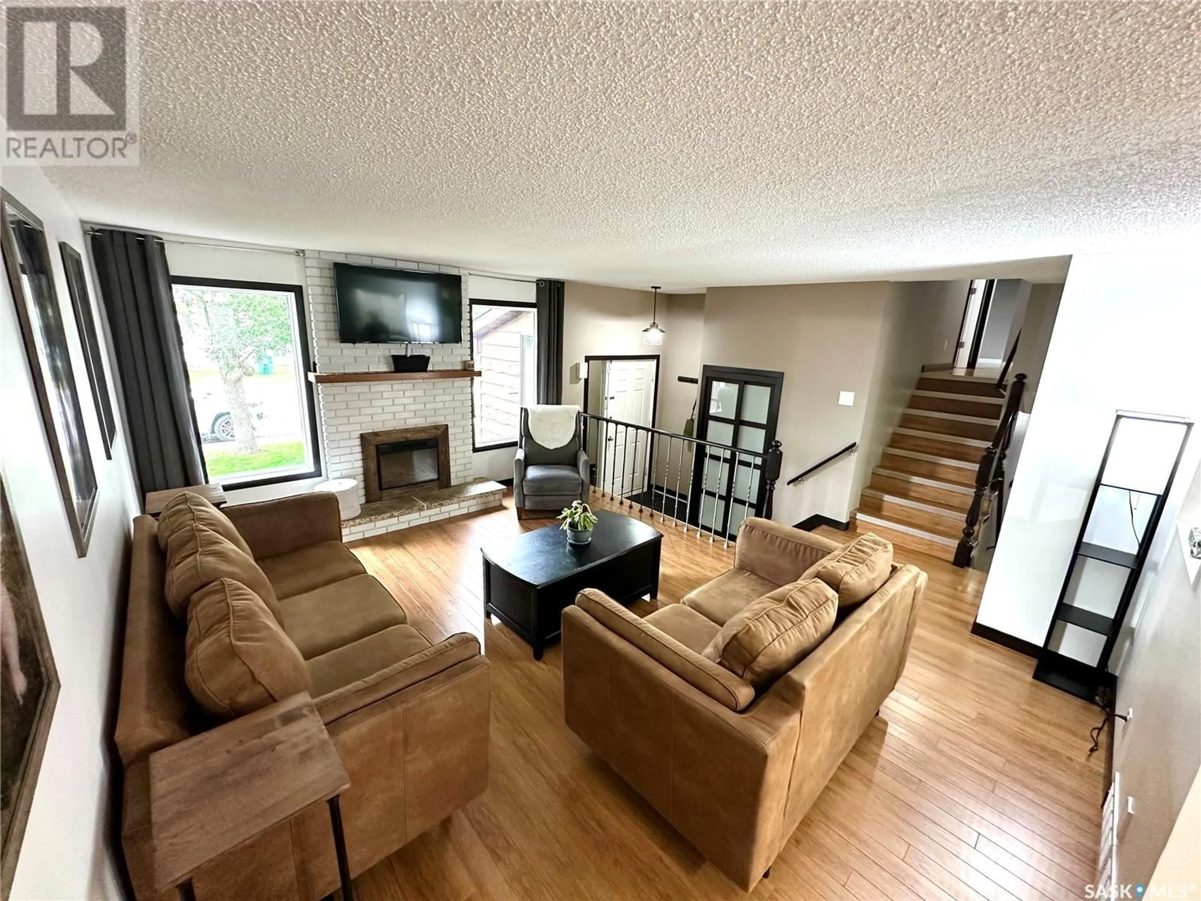 Living room with furniture, wood/laminate floor for 703 MCCORMACK ROAD, Saskatoon Saskatchewan S7M5B9
