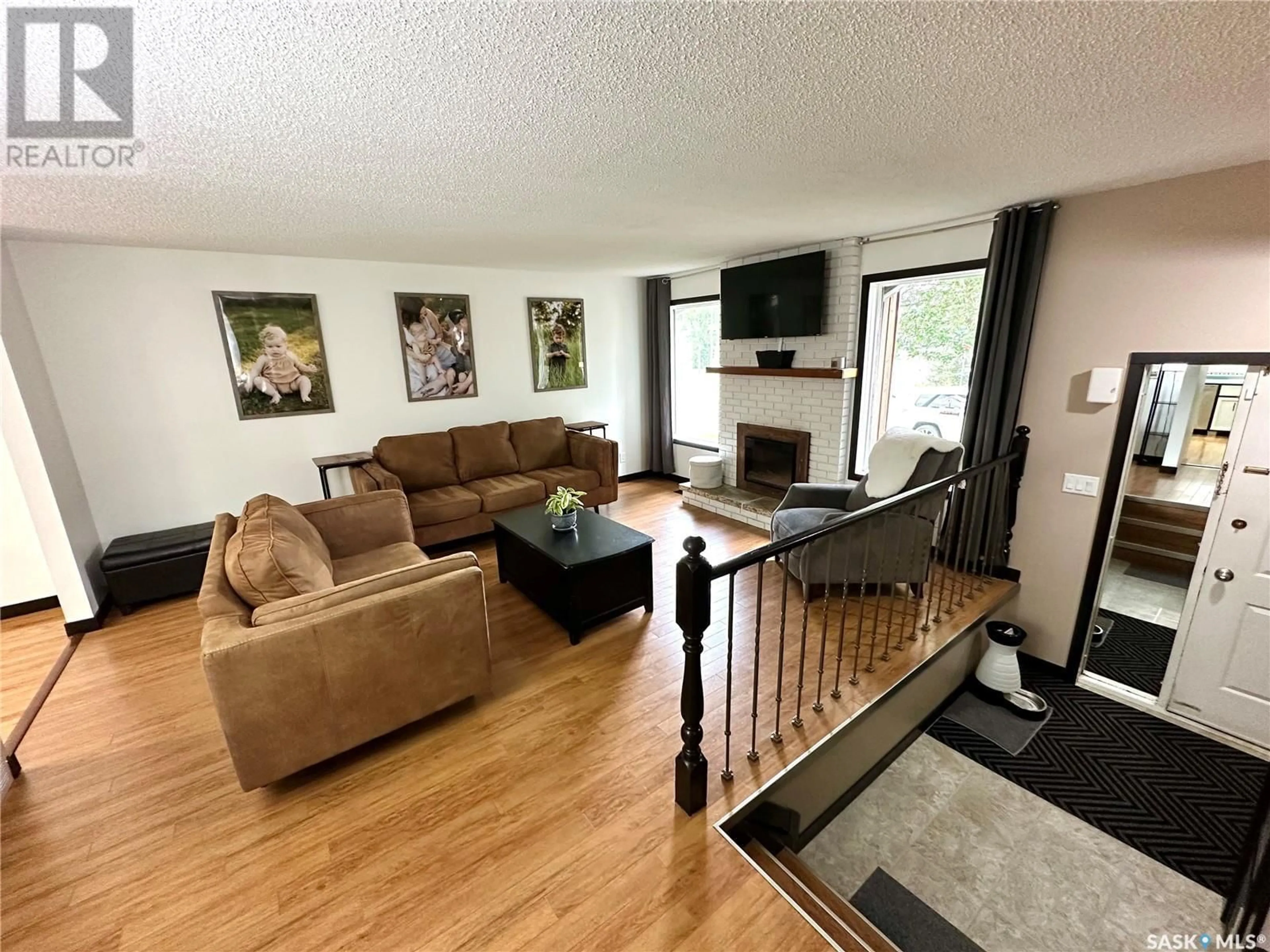 Living room with furniture, wood/laminate floor for 703 MCCORMACK ROAD, Saskatoon Saskatchewan S7M5B9