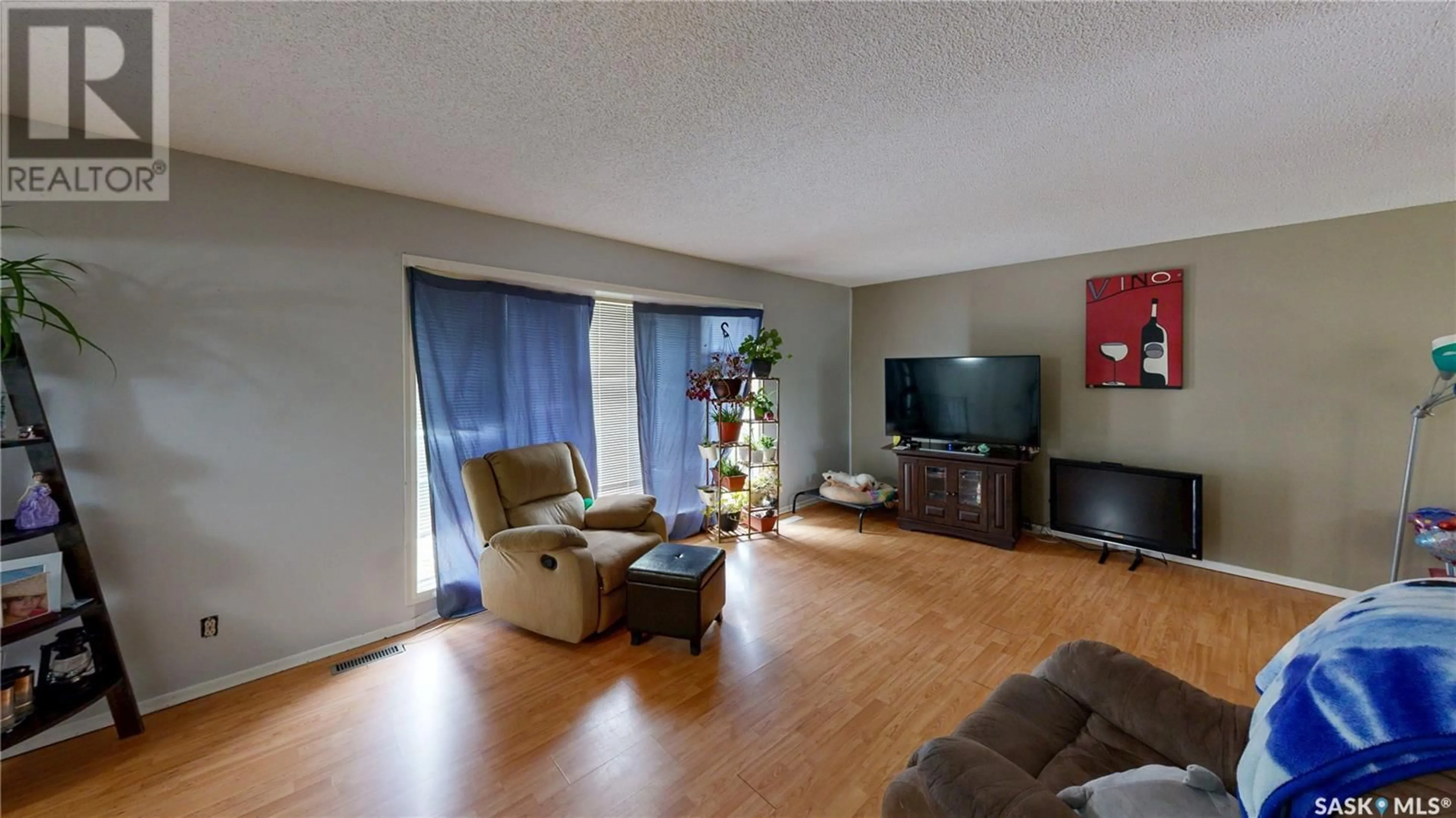 Living room with furniture, wood/laminate floor for 447 HABKIRK DRIVE, Regina Saskatchewan S4S6B2