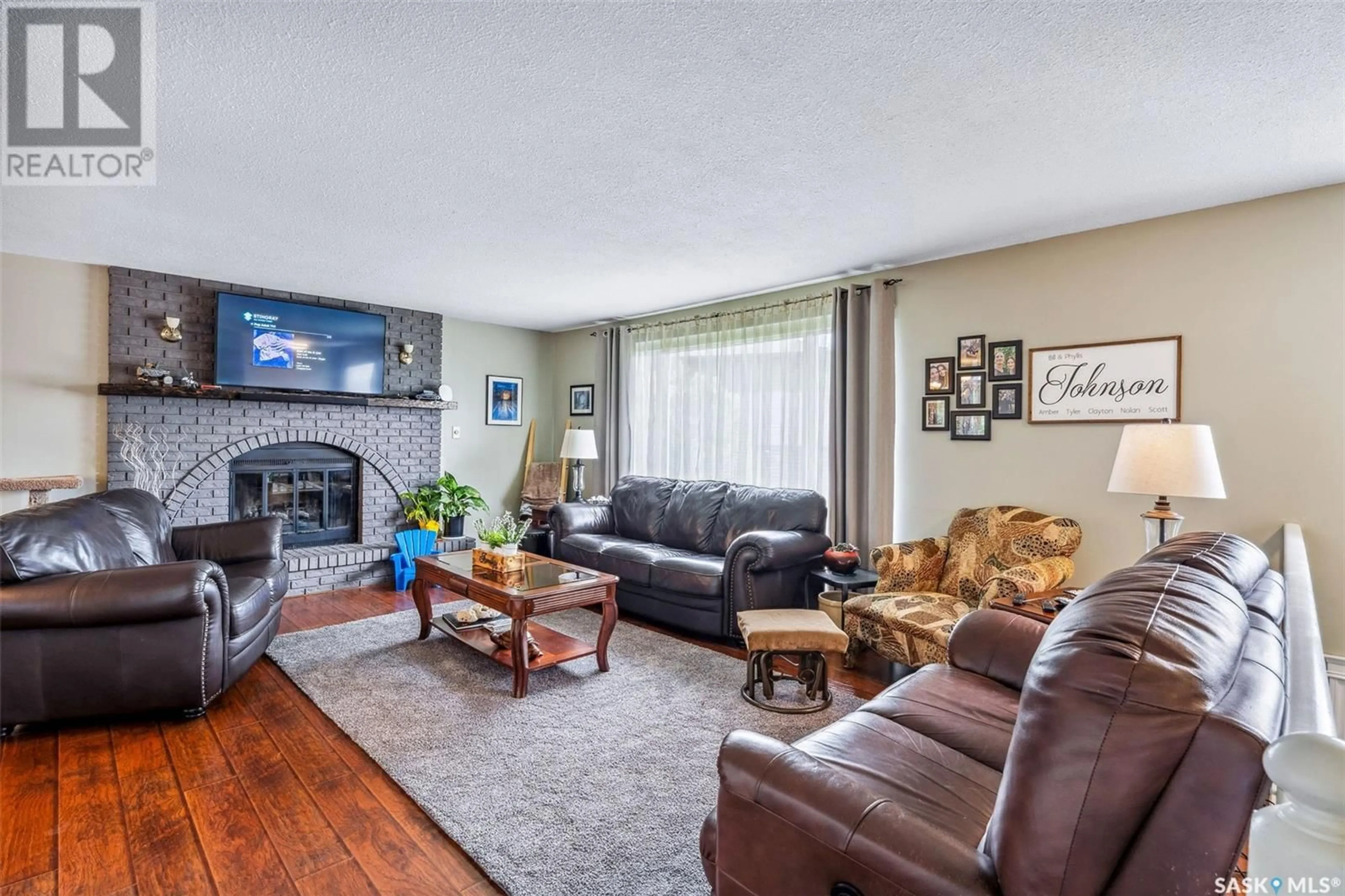Living room with furniture, wood/laminate floor for 1135 BASARABA PLACE, Prince Albert Saskatchewan S6V7K3