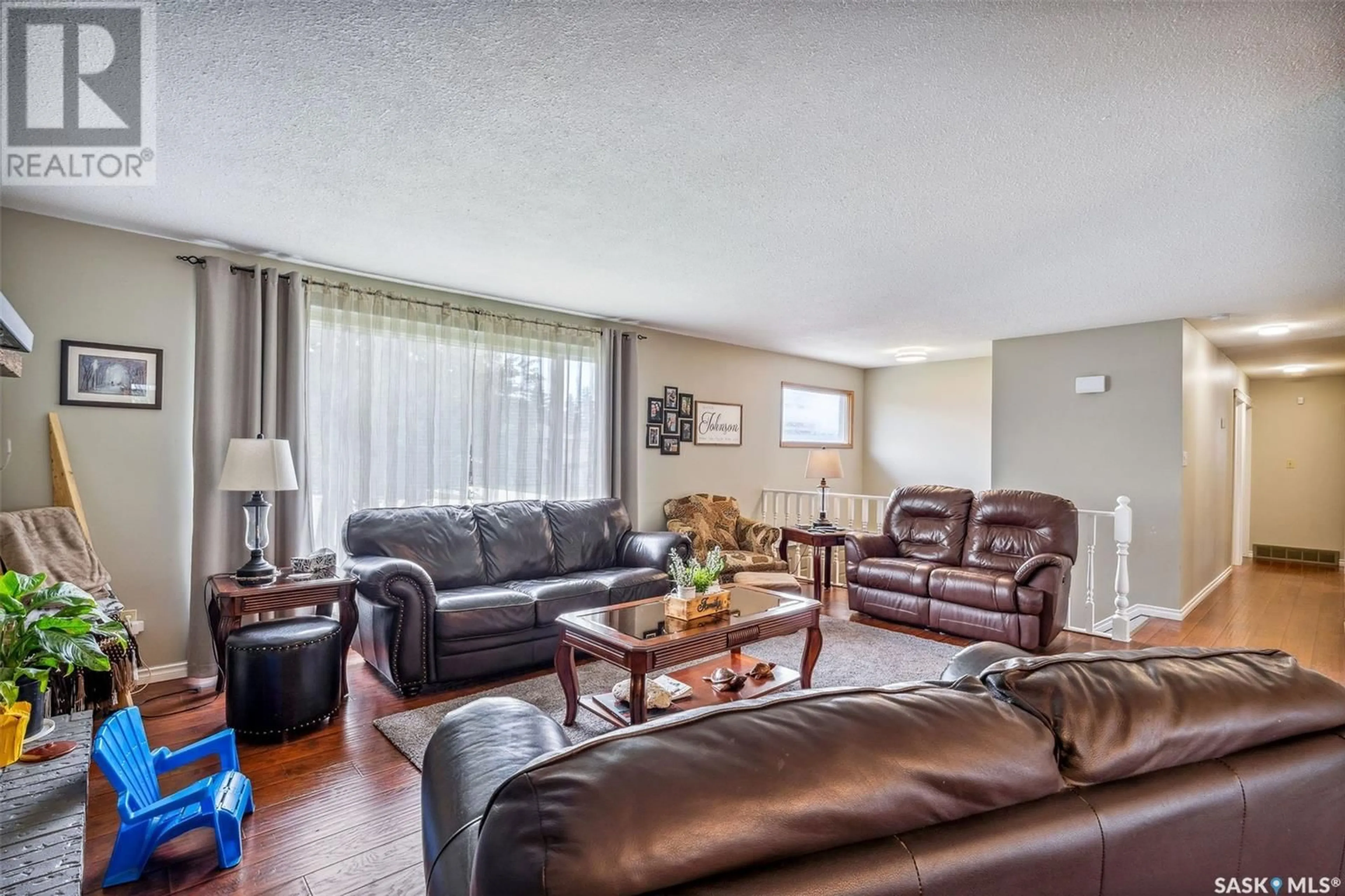 Living room with furniture, wood/laminate floor for 1135 BASARABA PLACE, Prince Albert Saskatchewan S6V7K3