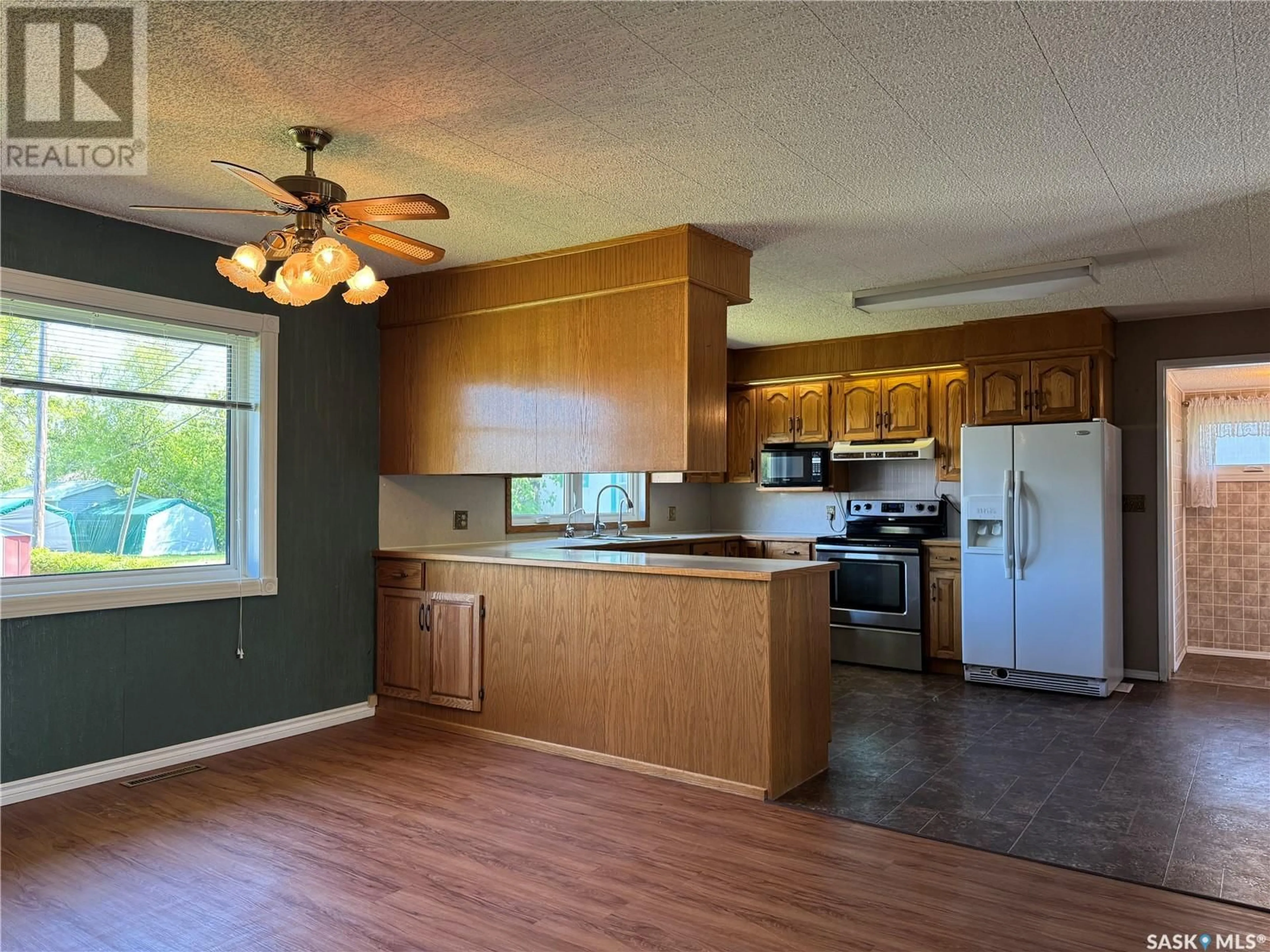 Open concept kitchen, wood/laminate floor for 409 3RD AVENUE, Kelliher Saskatchewan S0A1V0