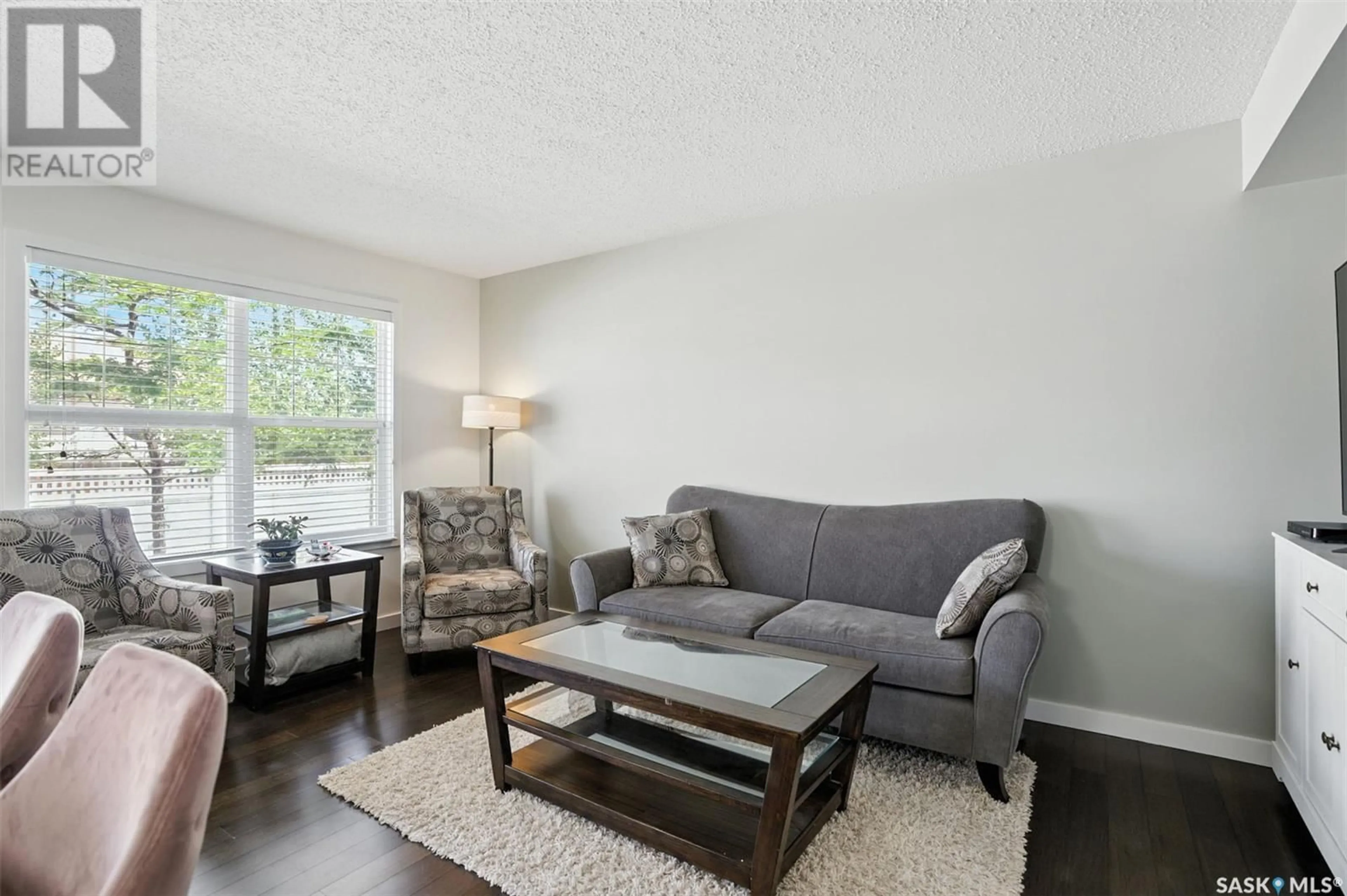 Living room with furniture, wood/laminate floor for 410 - 303 LEDINGHAM WAY, Saskatoon Saskatchewan S7V0C4