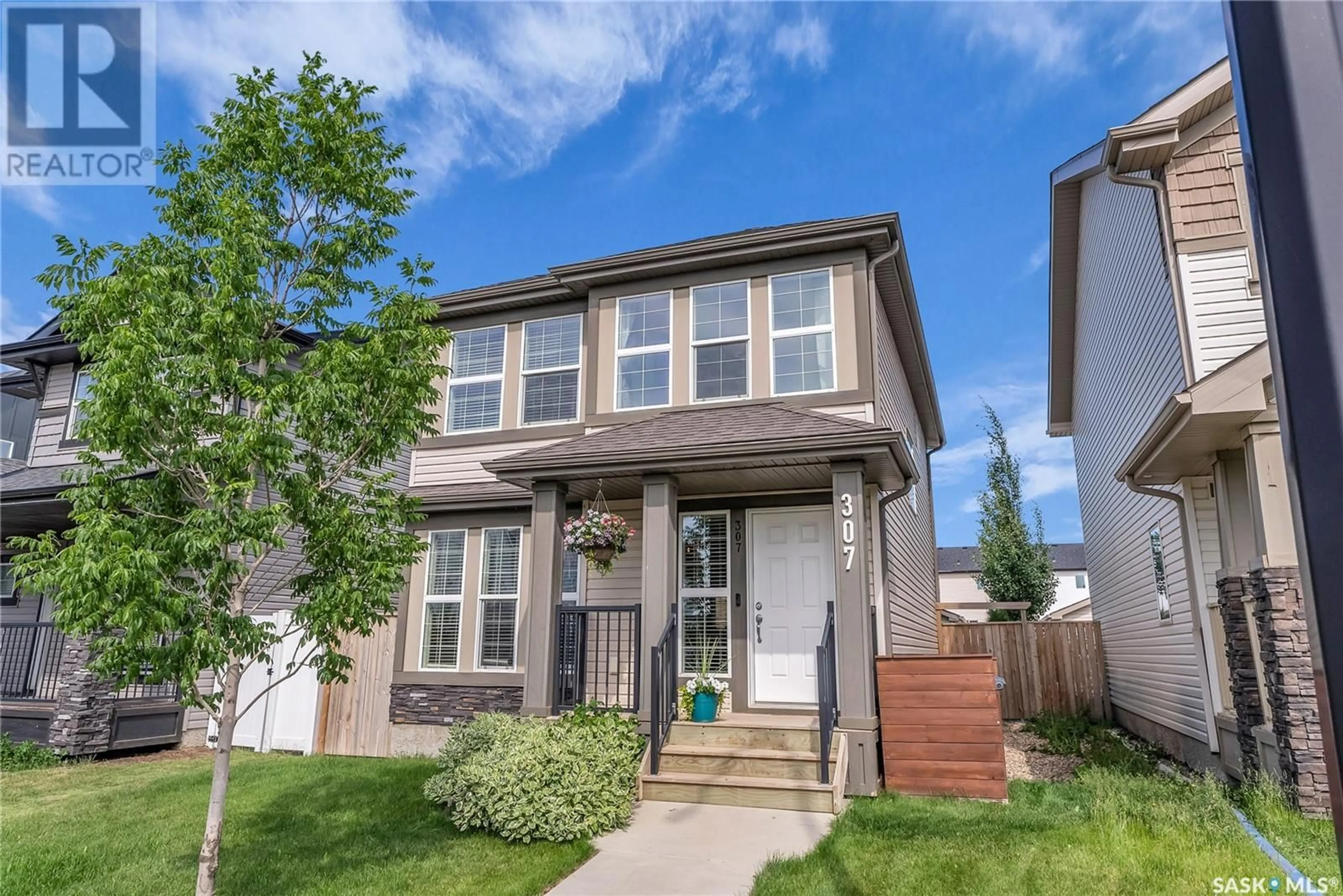 Home with vinyl exterior material, street for 307 DELAINEY MANOR, Saskatoon Saskatchewan S7V0N2