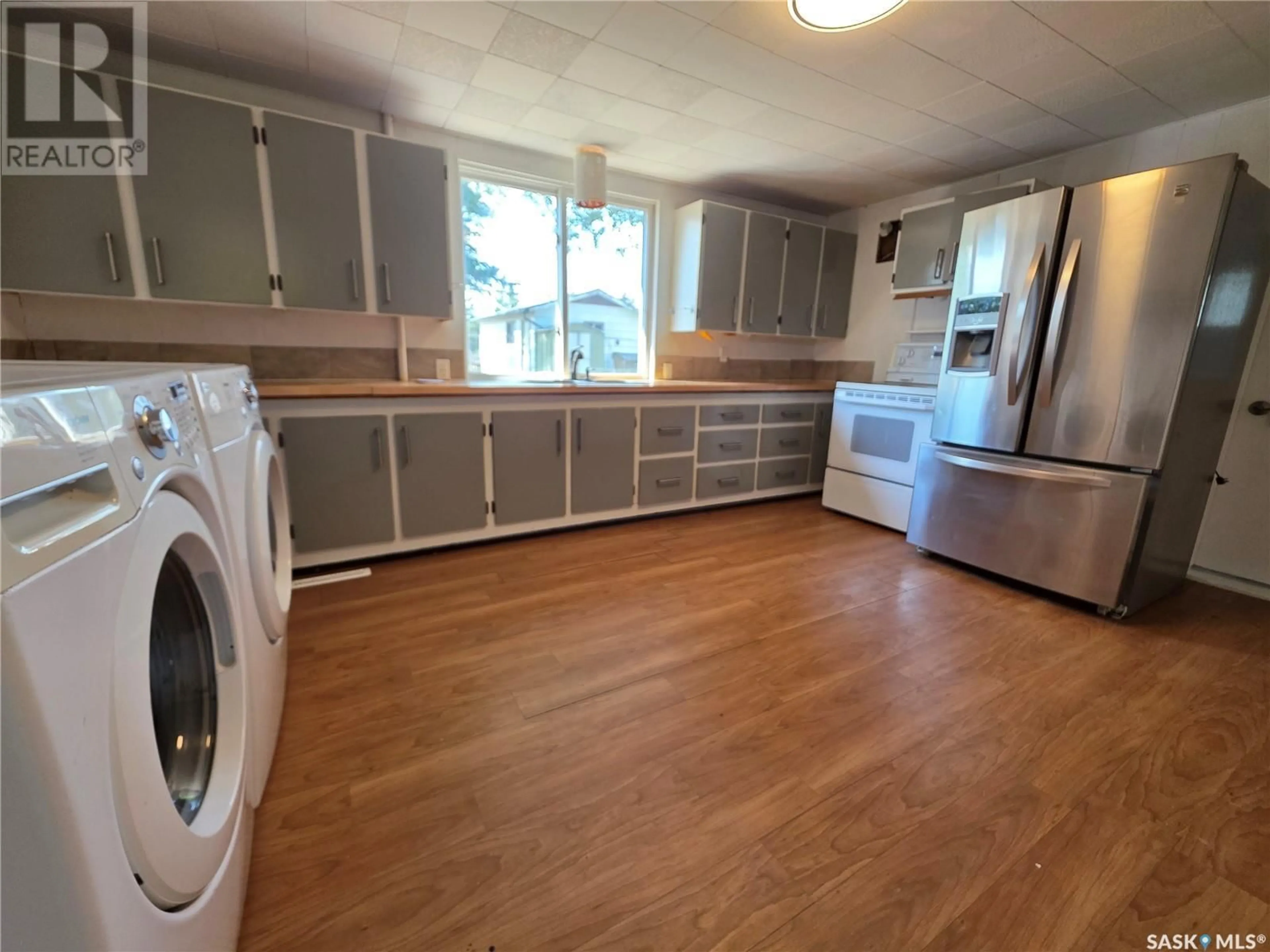Kitchen with laundary machines, wood/laminate floor for 1001 HERBERT AVENUE, Herbert Saskatchewan S0H2A0