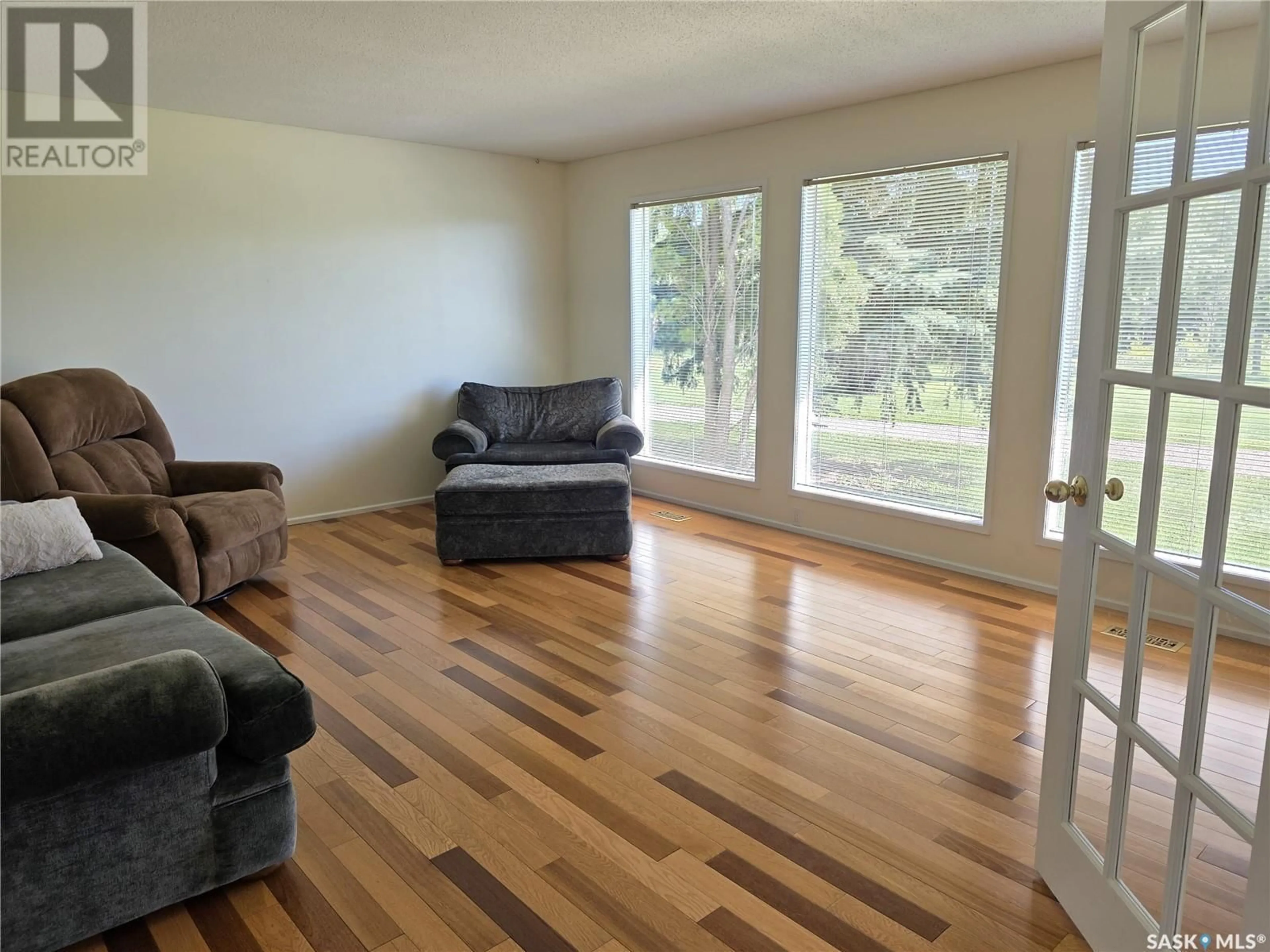 Living room with furniture, wood/laminate floor for KENASTON ACREAGE, Mccraney Rm No. 282 Saskatchewan S0G2N0