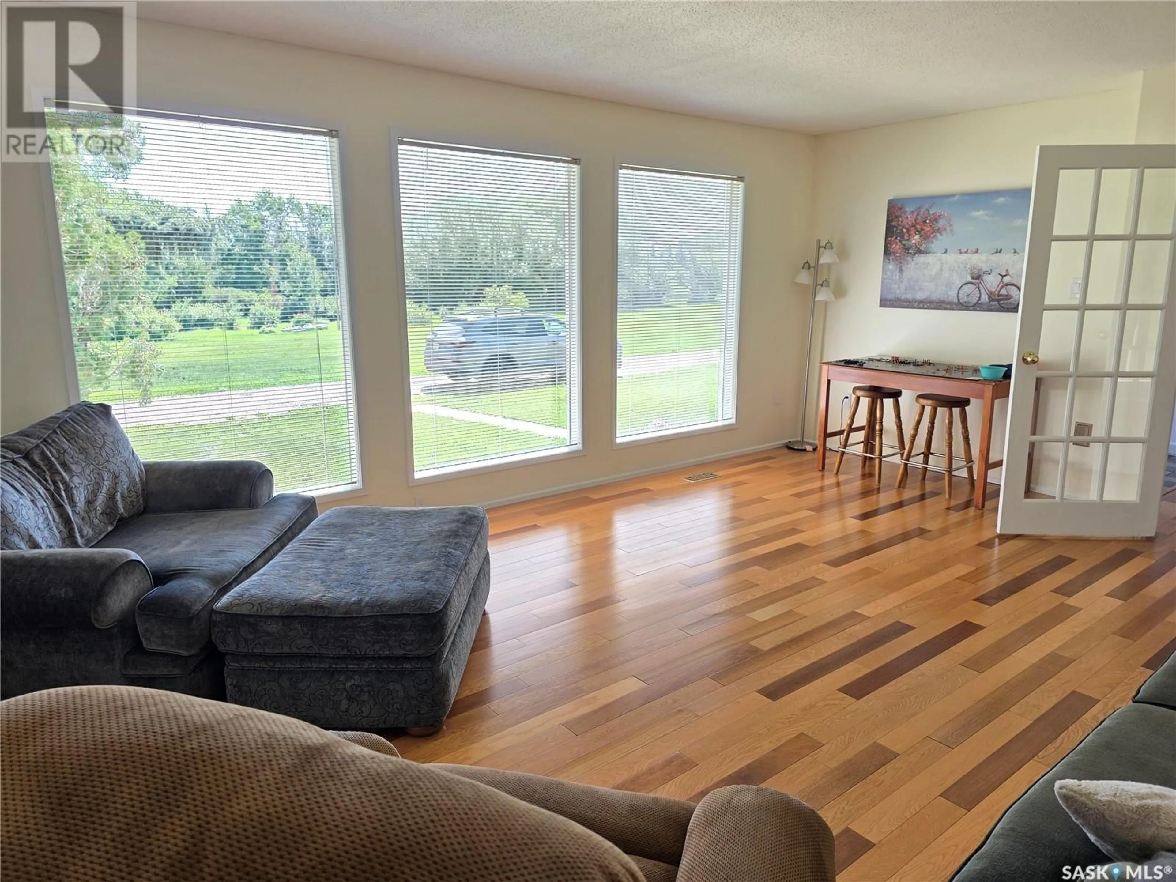 Living room with furniture, wood/laminate floor for KENASTON ACREAGE, Mccraney Rm No. 282 Saskatchewan S0G2N0