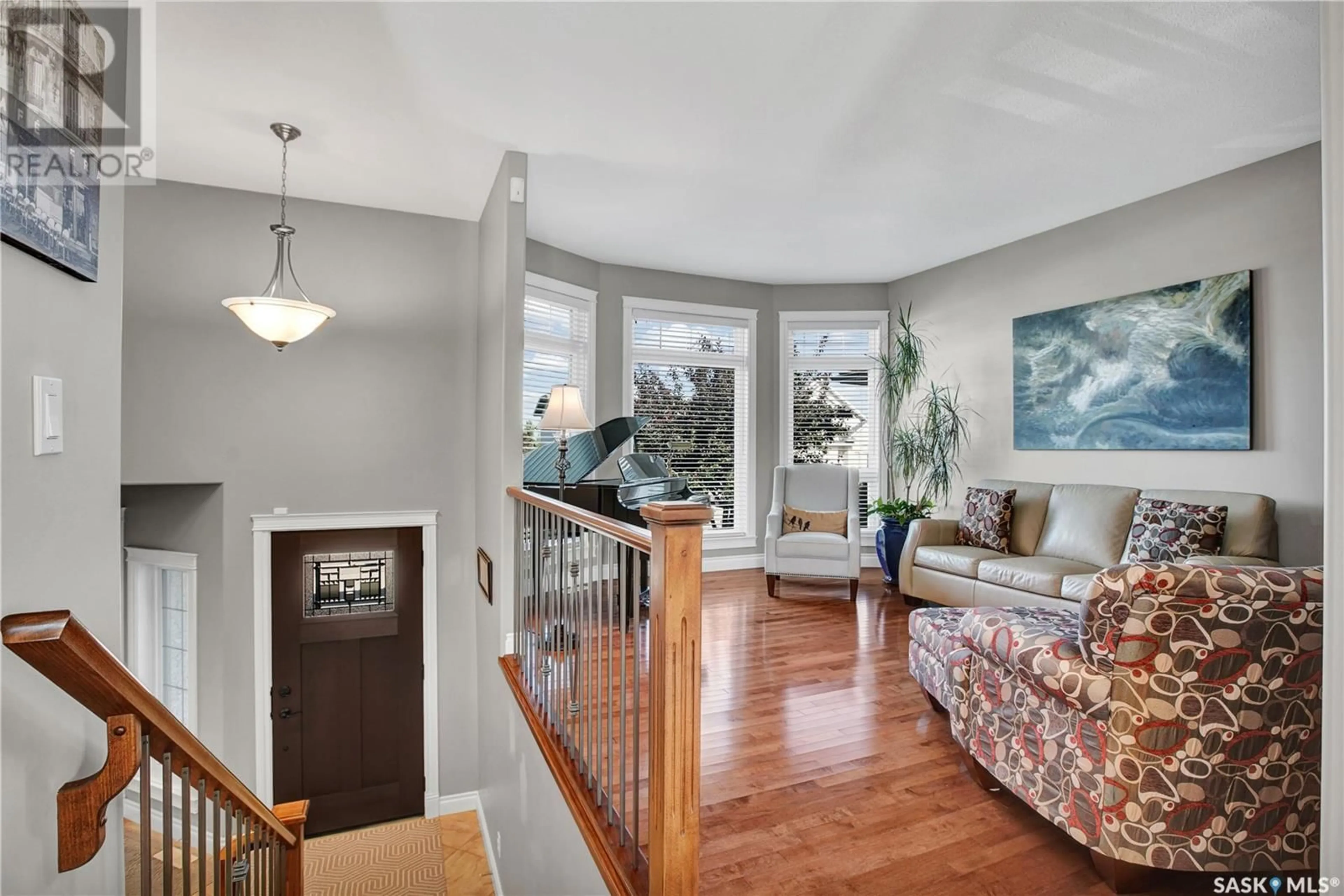 Living room with furniture, wood/laminate floor for 304 CORNERBROOK COURT, Warman Saskatchewan S0K0A1