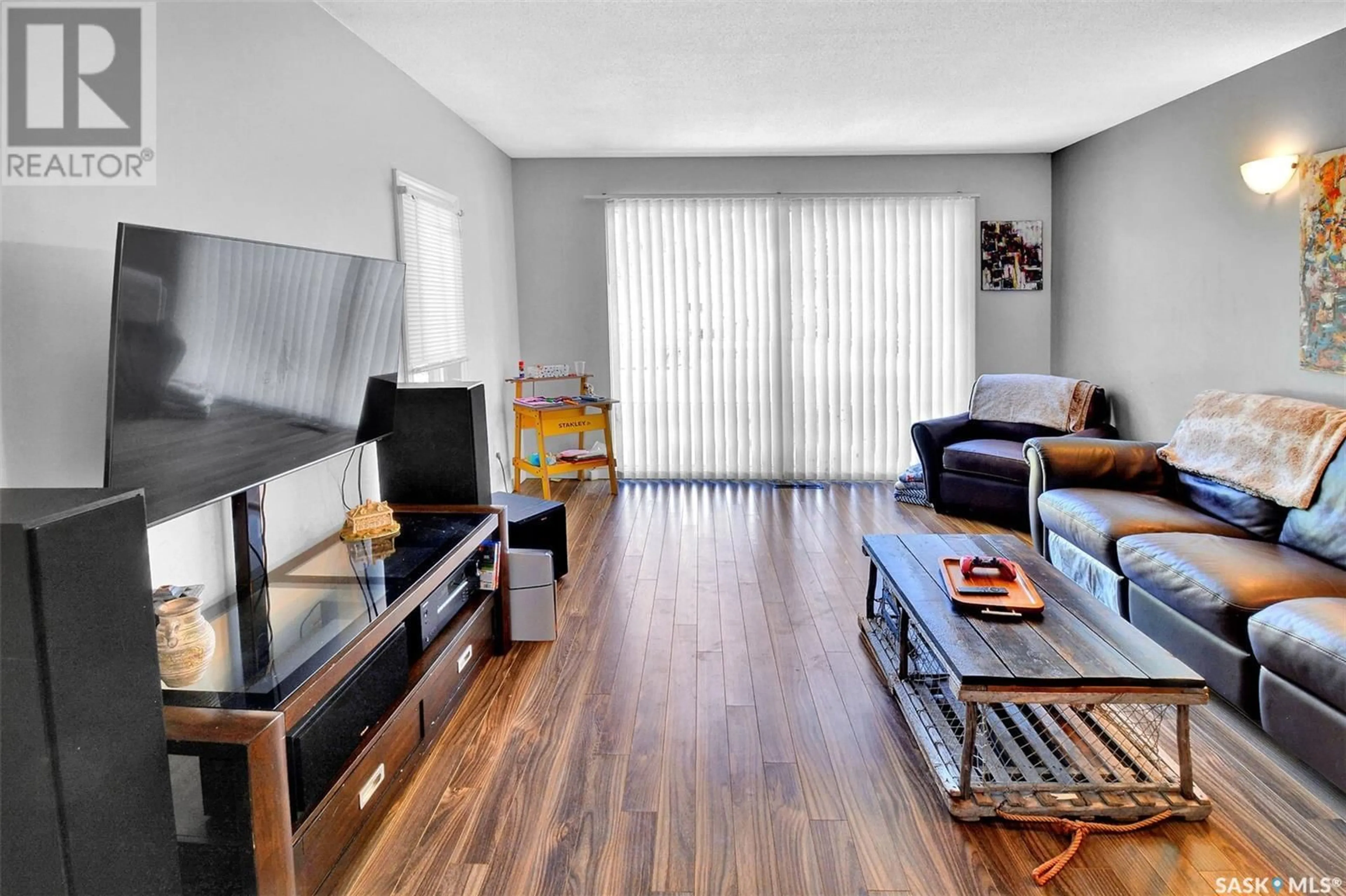 Living room with furniture, wood/laminate floor for 110 SPINKS DRIVE, Saskatoon Saskatchewan S7H4B9